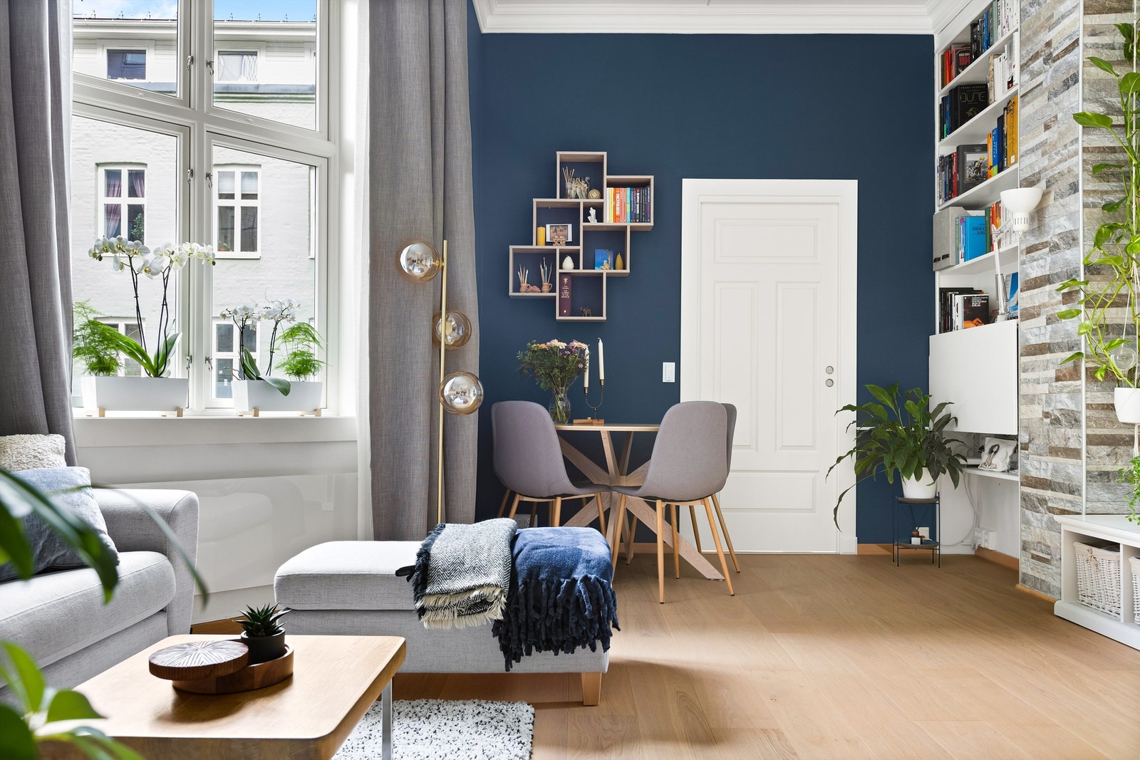 Den åpne stuen har store vindusflater som slipper inn rikelig med naturlig lys, noe som gir rommet en varm og innbydende følelse. Galleribilde