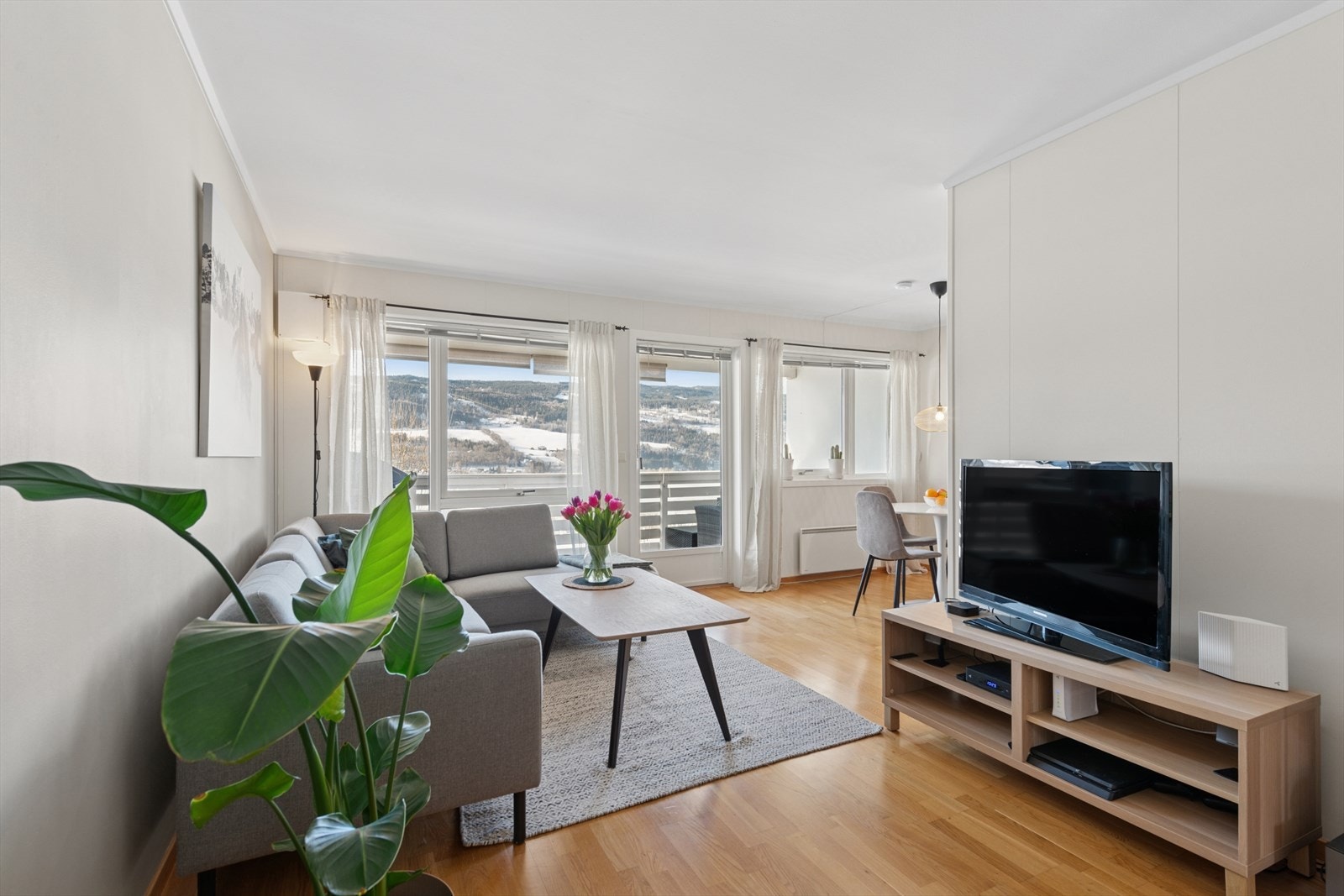 Innbydende stue med plass til sofagruppe og spisebord. Store vindusflater slipper inn rikelig med naturlig lys. Galleribilde