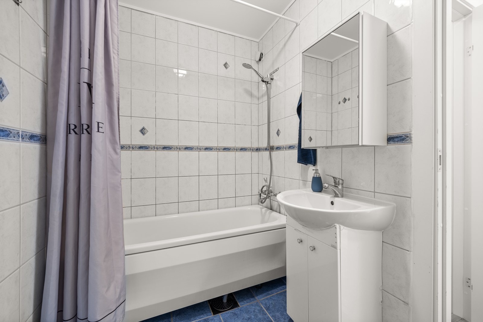 Badet er utstyrt med badekar, servant og speilskap Galleribilde