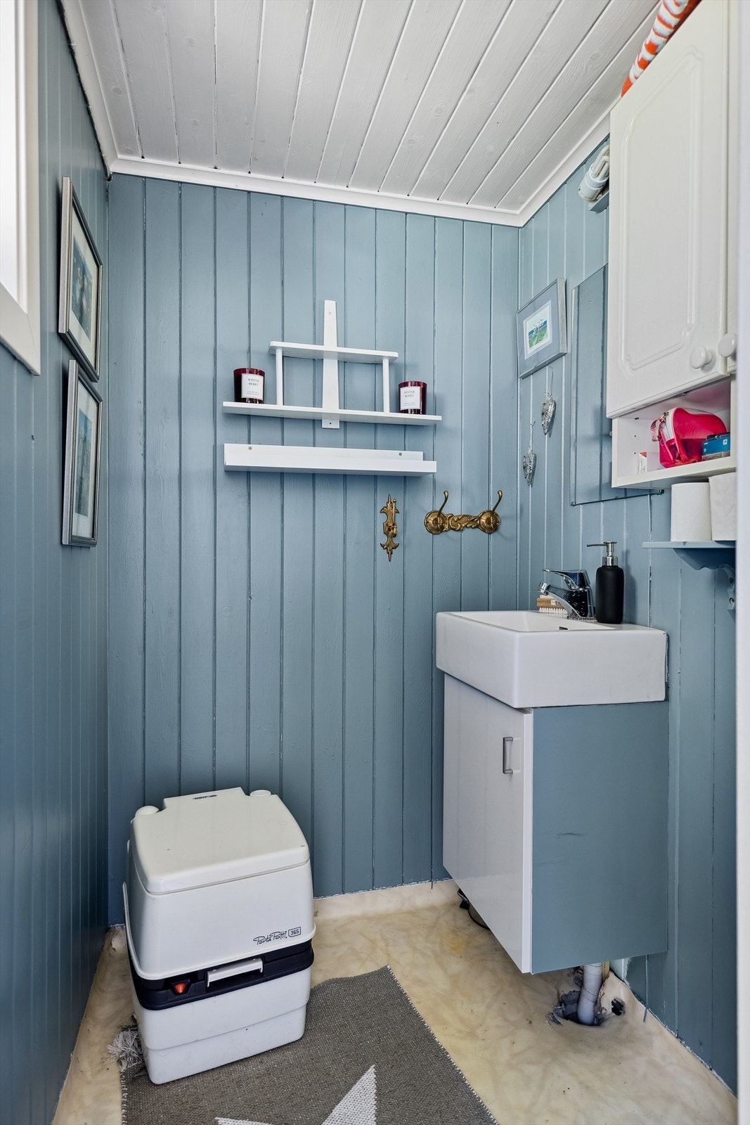 Toalettrom har skap med servant, overskap og Porta Potti kjemisk toalett. Galleribilde