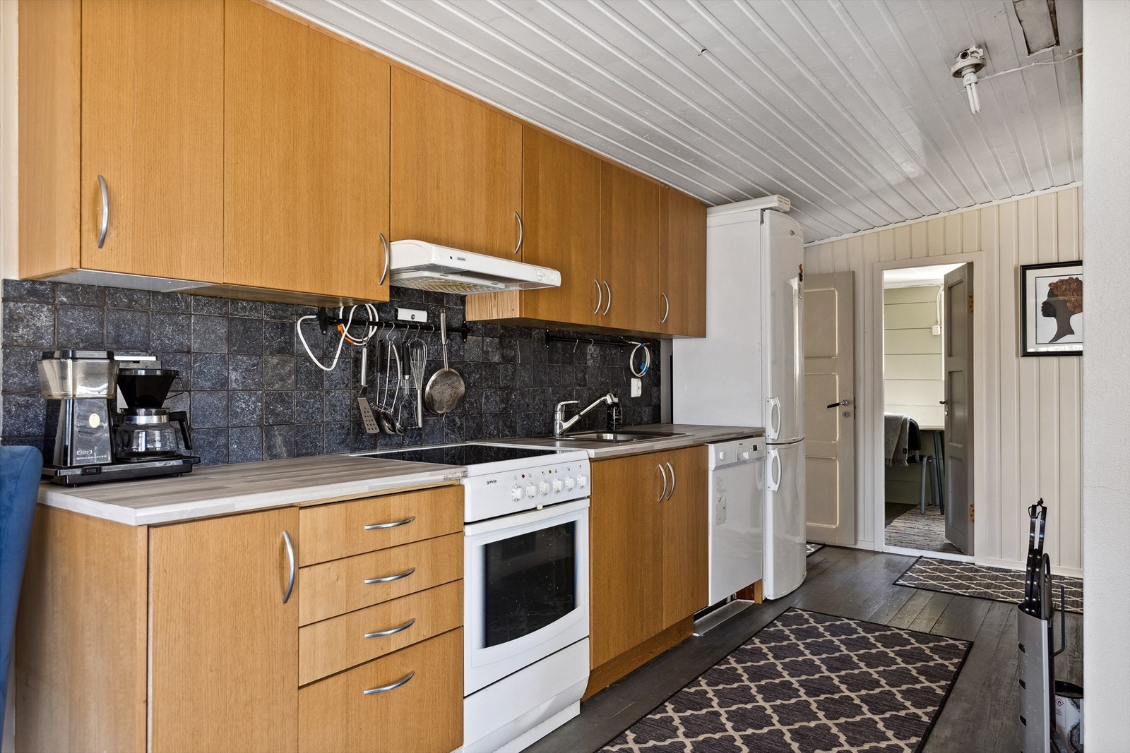 Kjøkkeninnredning med glatte fronter og laminat benkeplate. Her er det frittstående komfyr, oppvaskmaskin og kjøl/fryseskap som medfølger. Galleribilde