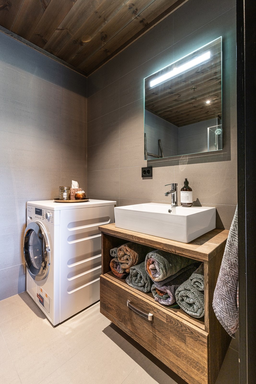 Baderom med opplegg for vaskemaskin tilknyttet hovedsoverommet. Galleribilde