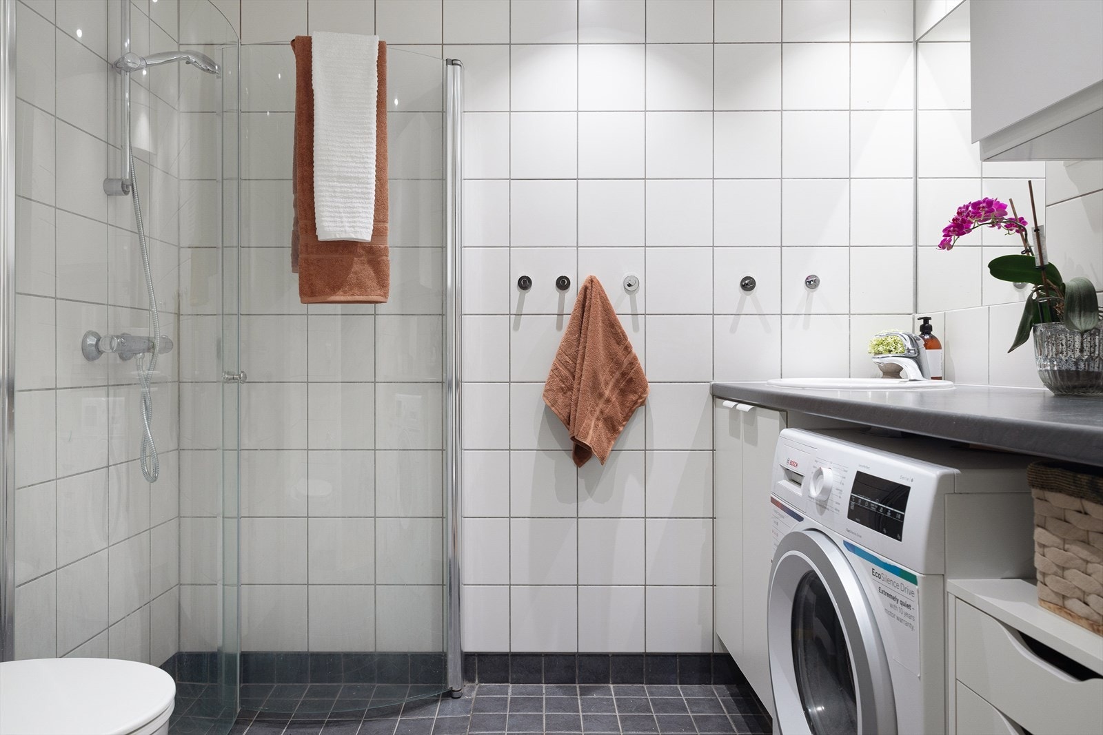 Det er innredet med veggmontert wc, dusjhjørne, innfellbare dusjdører, servant, servantskap. Galleribilde