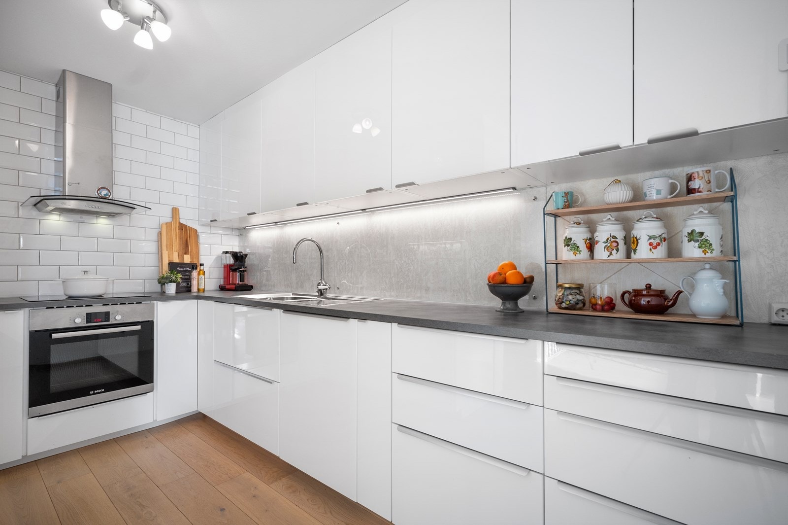 Stilrent kjøkken med slette, hvite fronter og laminert benkeplate. Galleribilde