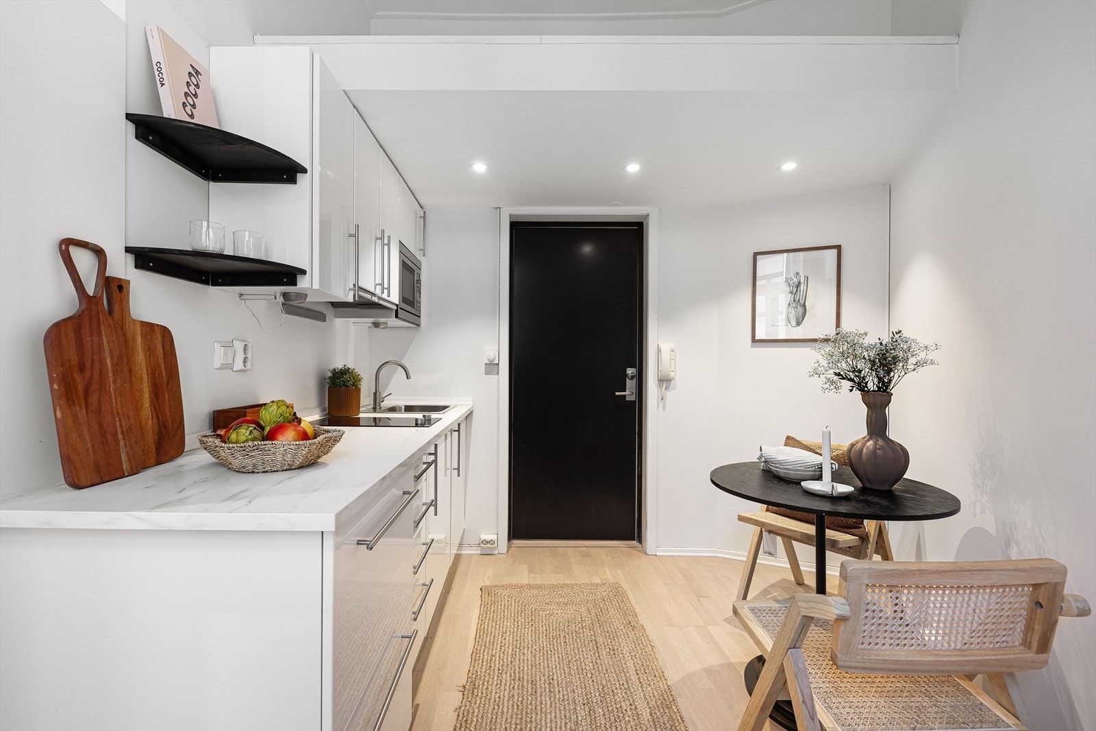 Tidløs kjøkkeninnredning med hvite glatte fronter og benkeplate i laminat. Galleribilde