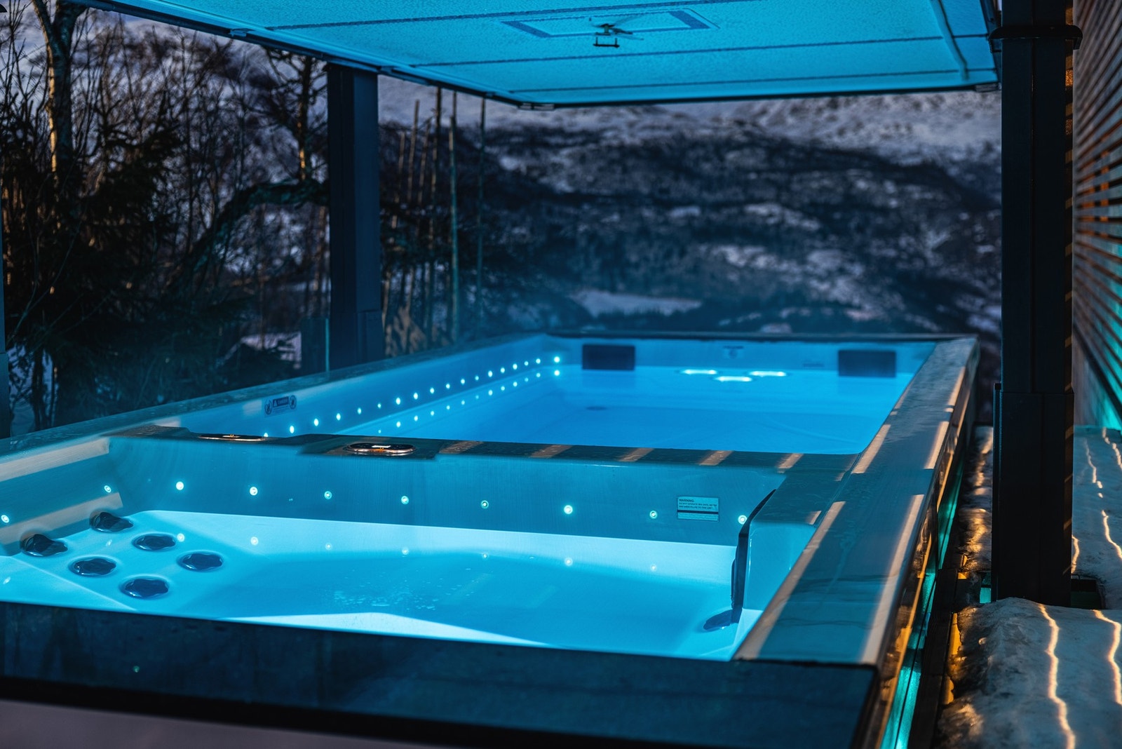 Utgang fra 2. etasje til 6 meter langt motstrømsbasseng og egen del med jacuzzi. Galleribilde