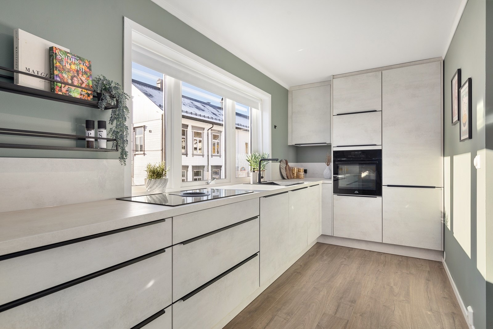 Legg merke til vifte integrert i platetoppen - samt de gjennomførte sorte detaljene på skap og skuffer Galleribilde