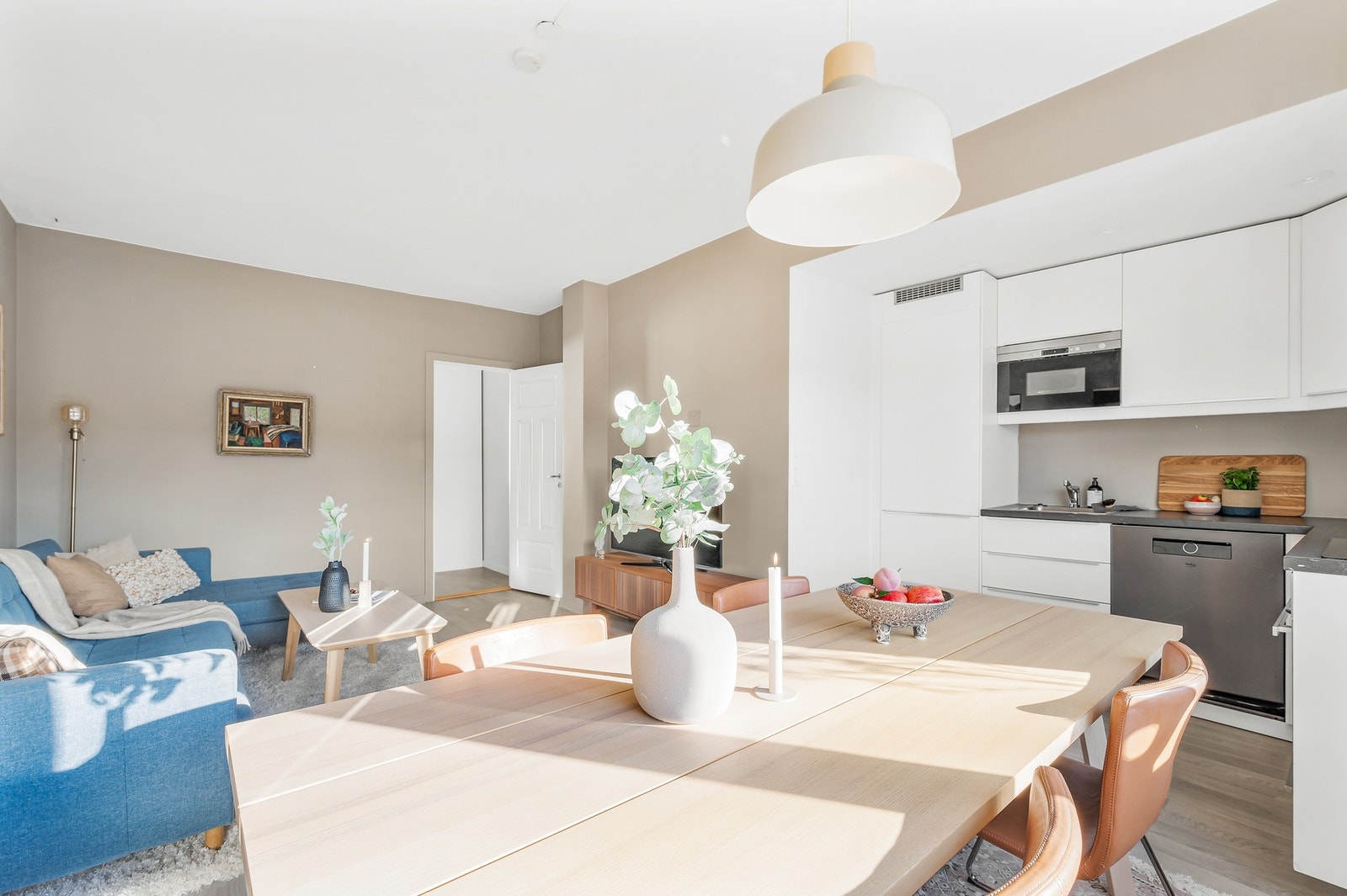 Kjøkkenet ligger praktisk til i et eget hjørne av stuen, som gir en sosial og åpen løsning. Galleribilde