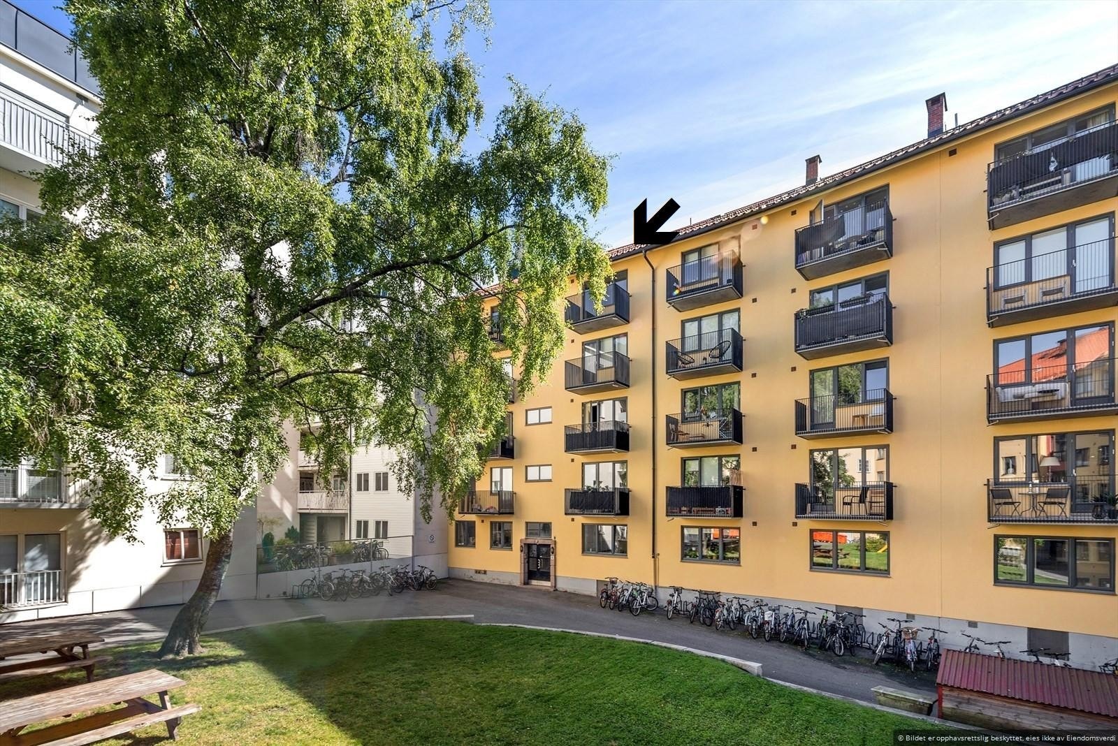 Leiligheten har en svært god intern beliggenhet i gården, her markert med pil på bildet. Galleribilde