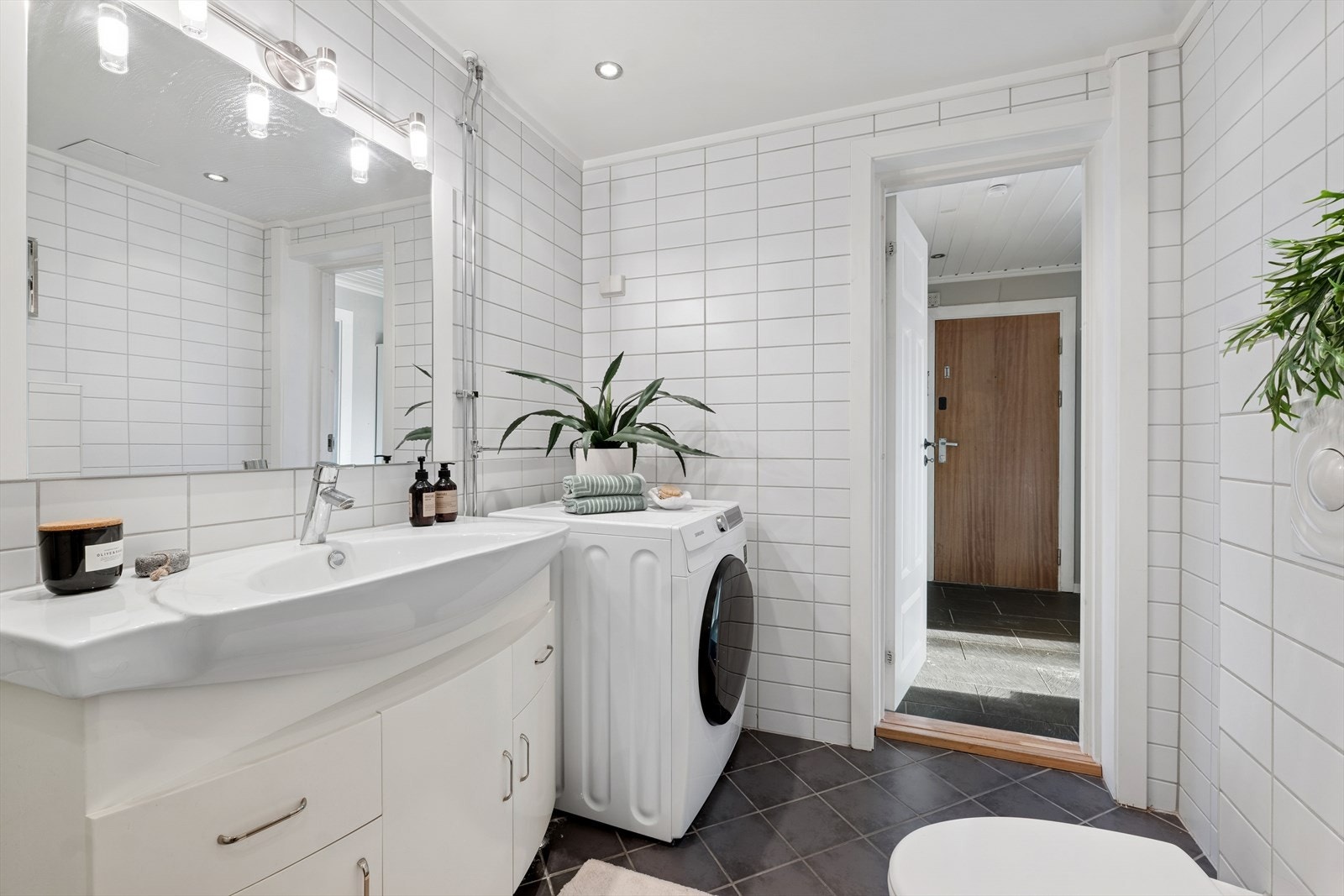 Badet er utstyrt med vegghengt toalett, dusjhjørne med svingbare dører og servantinnredning med skuffer og skapdører. Rommet har blitt utvidet i senere tid. Galleribilde