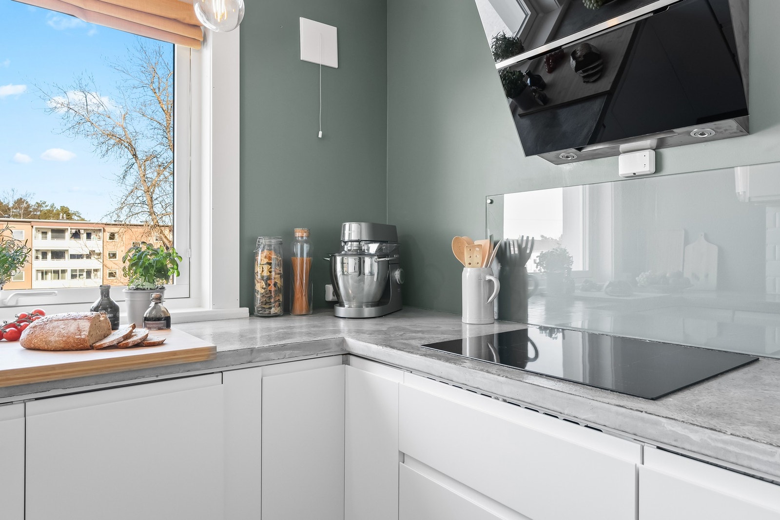 Innredningen fra Ikea har hvite, glatte fronter, takhøye skap og grå benkeplate i plasstøpt betong med nedfelt kum i stål. Galleribilde