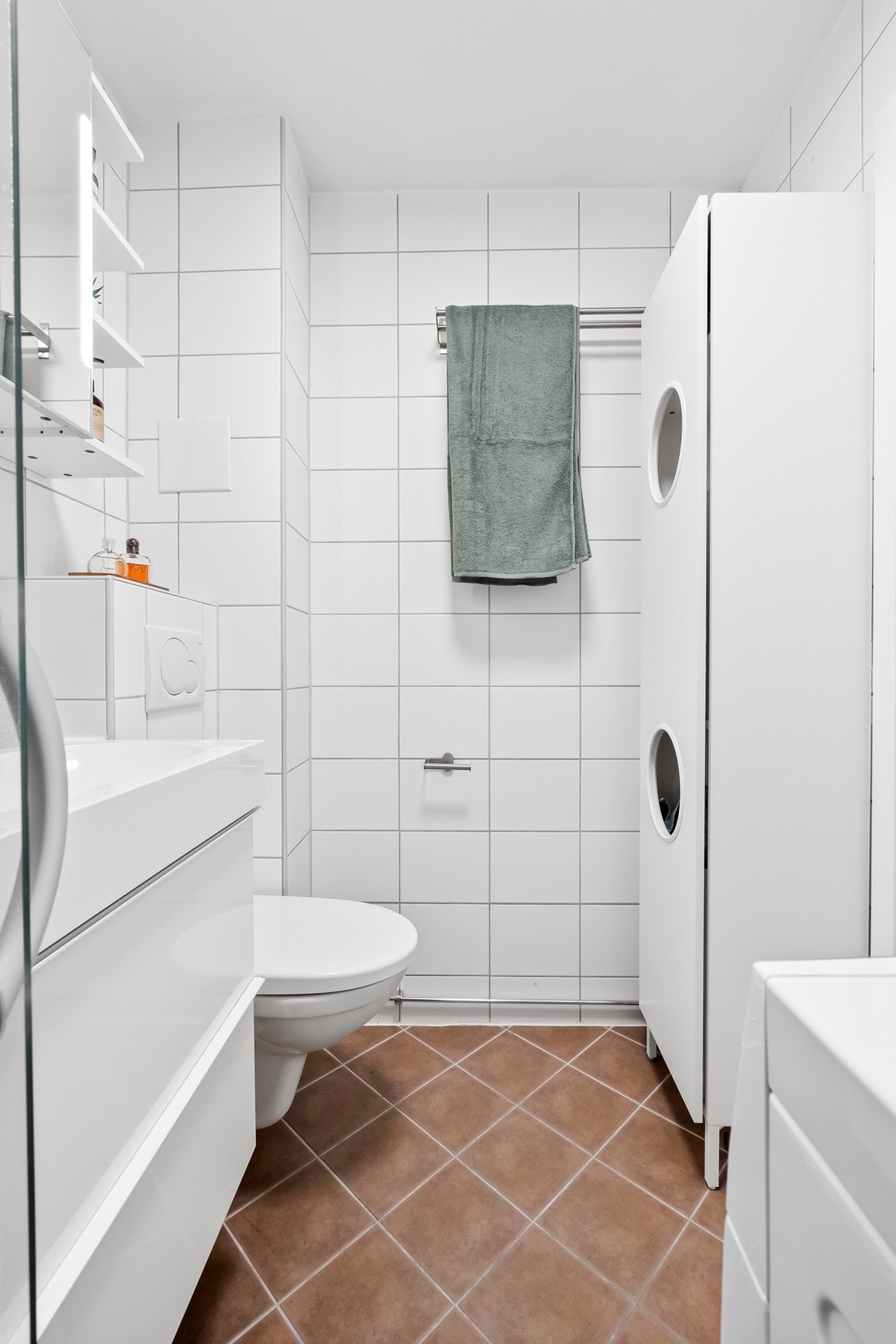 Baderomsinnredningen består av en heldekkende servant på en skuffeseksjon og et dobbelt speilskap med hyller og belysning. Videre er badet utstyrt med vegghengt toalett, dusjhjørne. Galleribilde