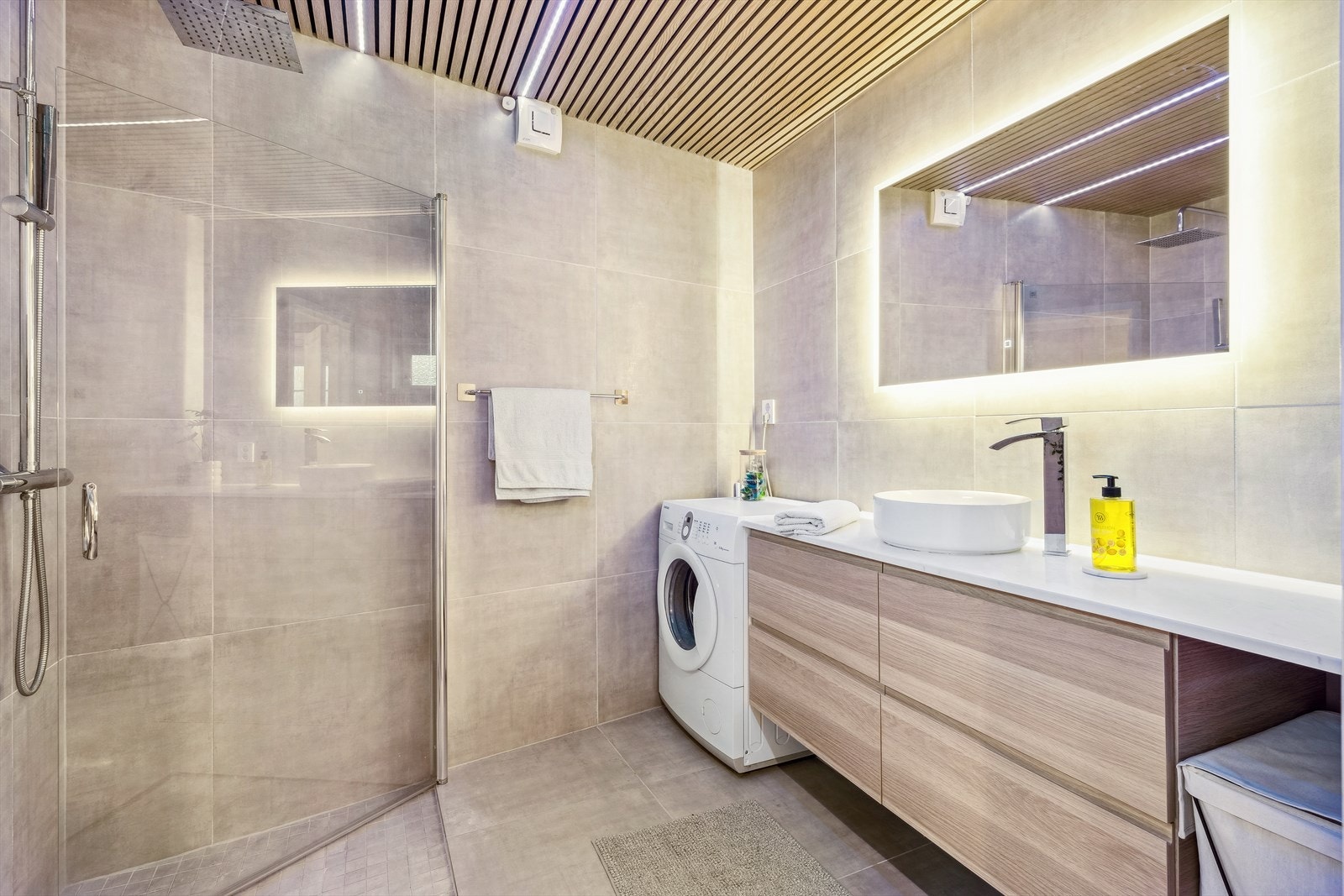 Badet inneholder toalett, dusjhjørne og servant med skapinnredning. Opplegg for vaskemaskin. Galleribilde