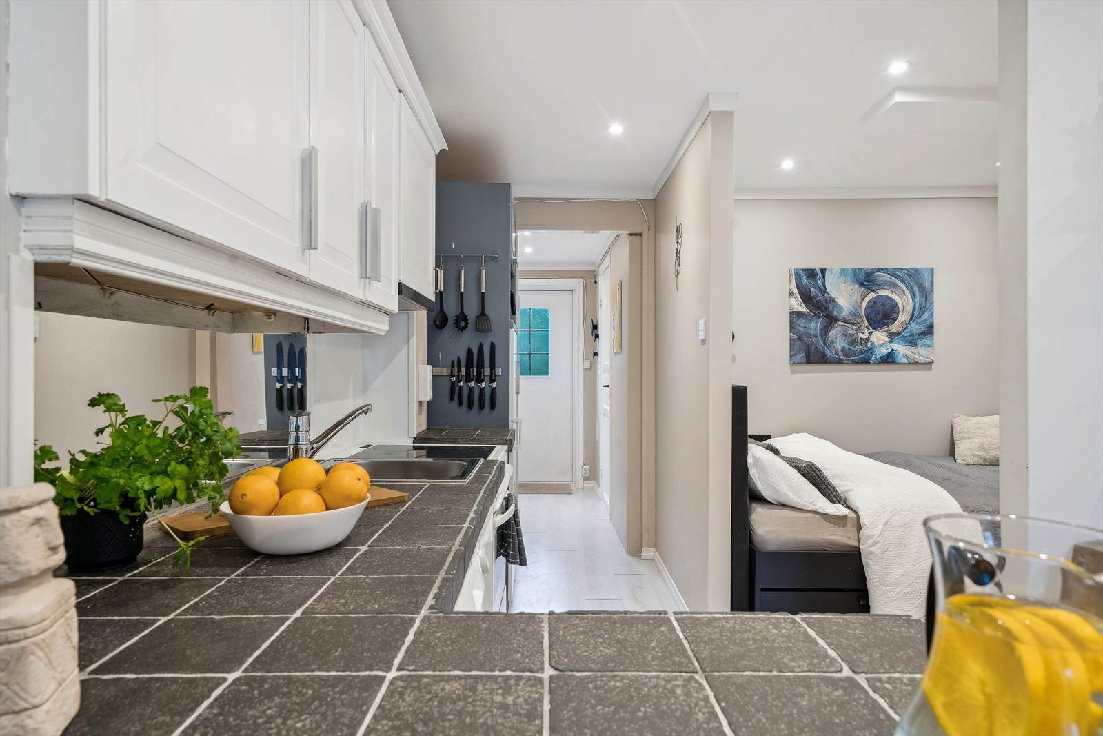 Leilighetens kjøkken har profilerte fronter og flislagt benkeplate Galleribilde