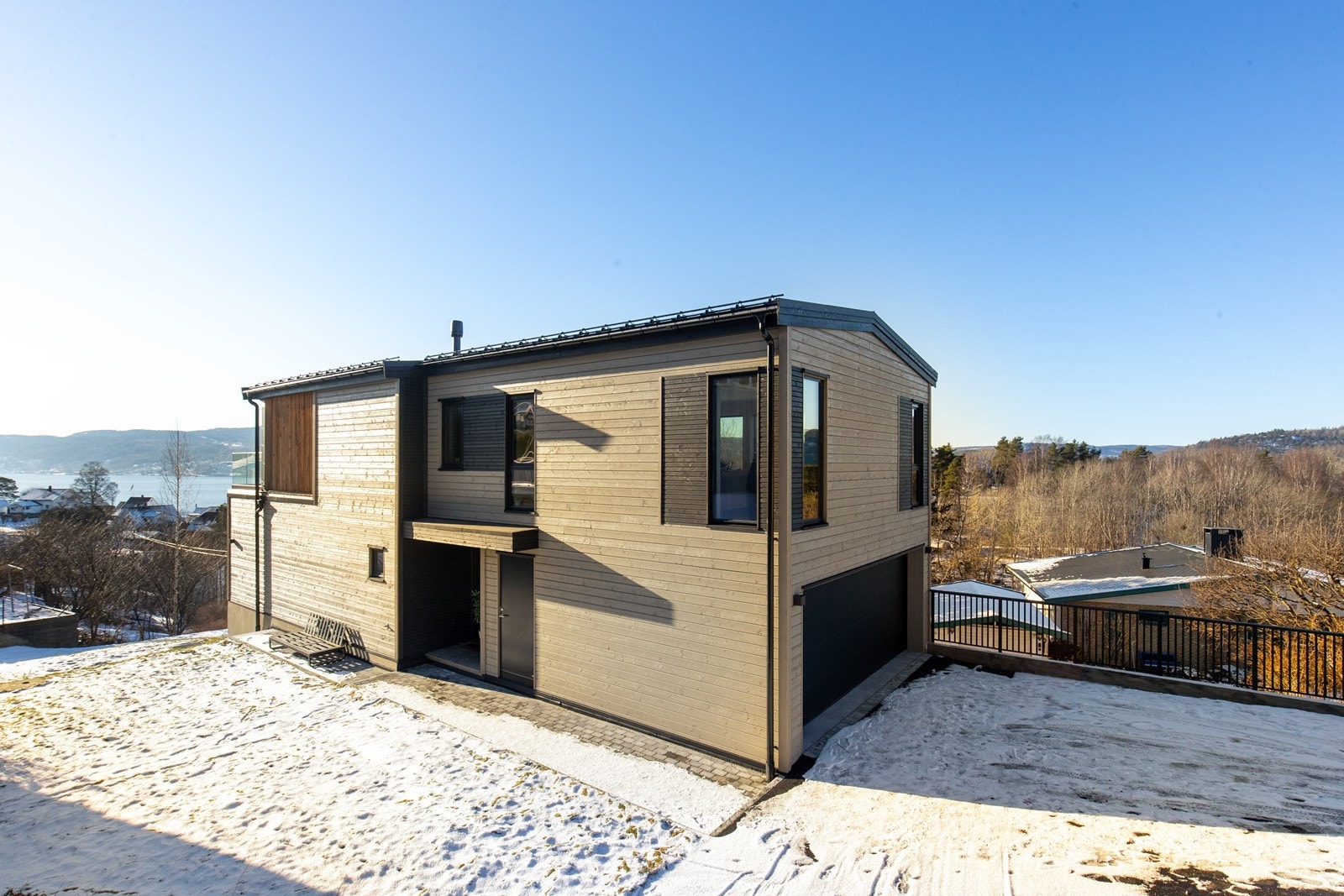 Fasade - asfaltert adkomst foran garasjen, steinbelagt frem til inngangsparti. Gressplen og granitt trapp. Galleribilde