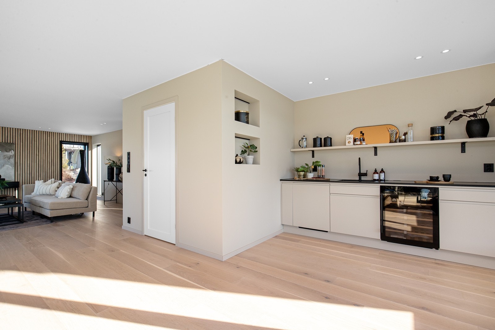 Stue i toppetasjen med kjøkken i forbindelse med terrassen. Integrert kjøleskap og vinskap. Galleribilde