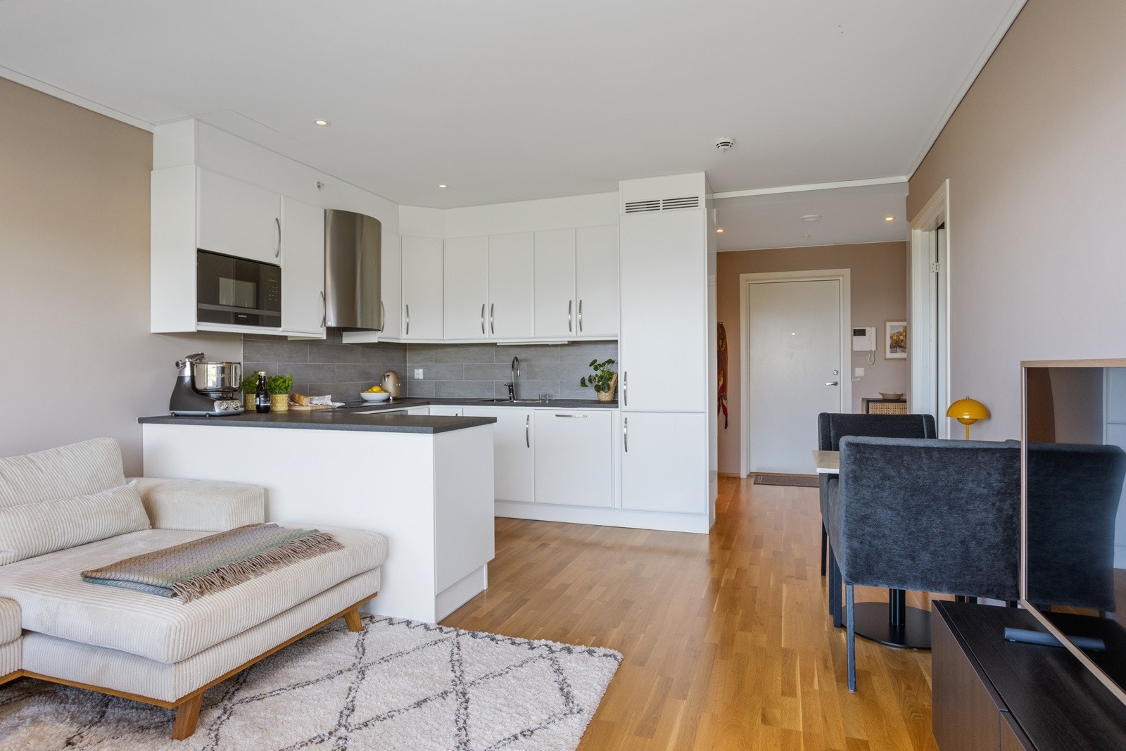 Oppholdsrommet er innredet med en hyggelig spiseplass ved kjøkkenet, sofagruppe, TV-hjørne og tilhørende møblement Galleribilde