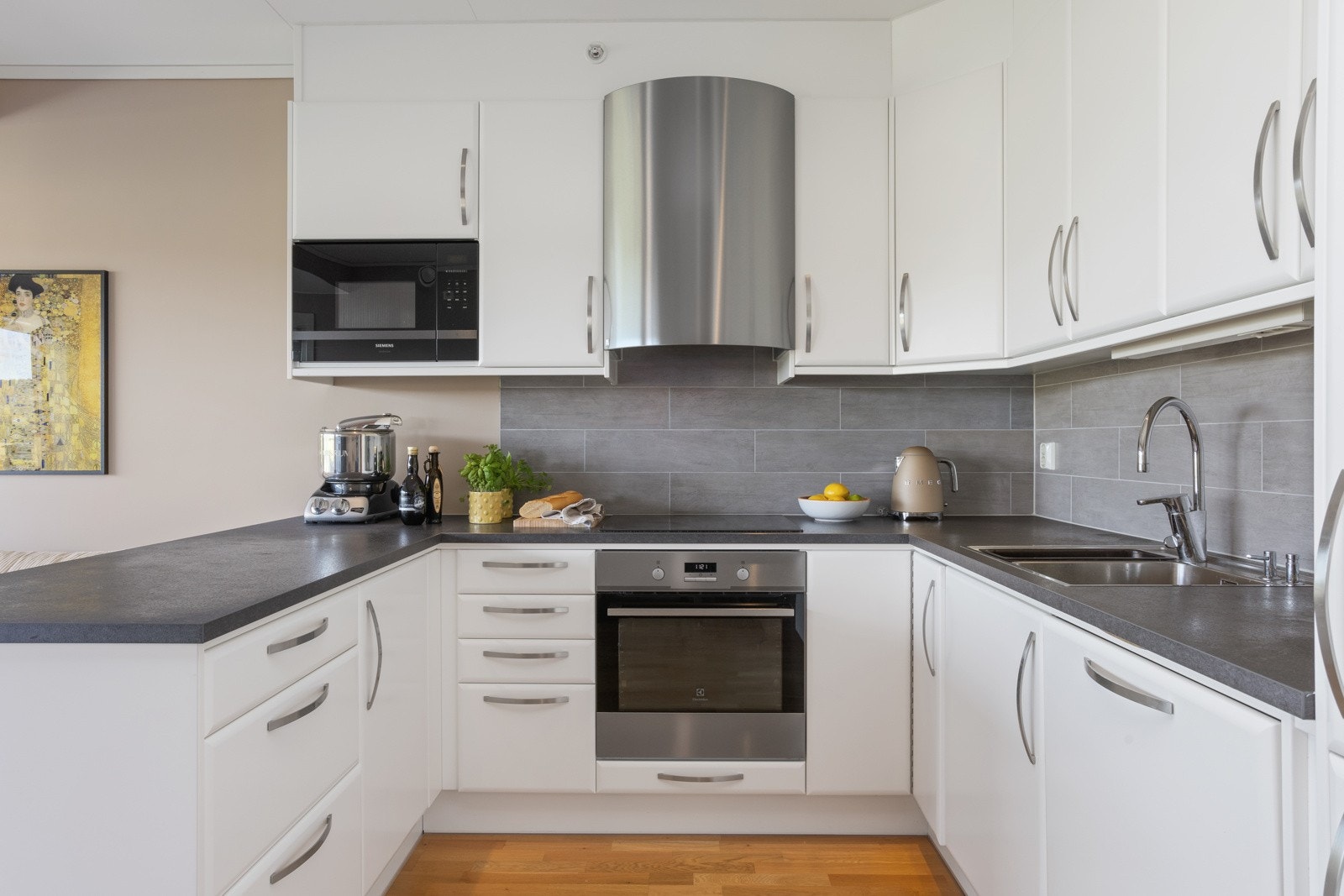 Kjøkkenet har integrert stekeovn, platetopp, oppvaskaskin, mikrobølgeovn og kjøleskap med frysedel Galleribilde