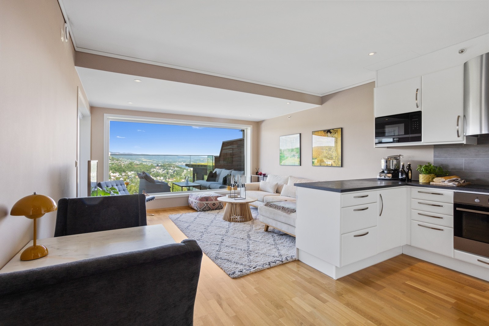 Stuen ligger i en åpen og moderne løsning mot kjøkkenet. Kjøkkenøyen deler naturlig rommet i to soner Galleribilde