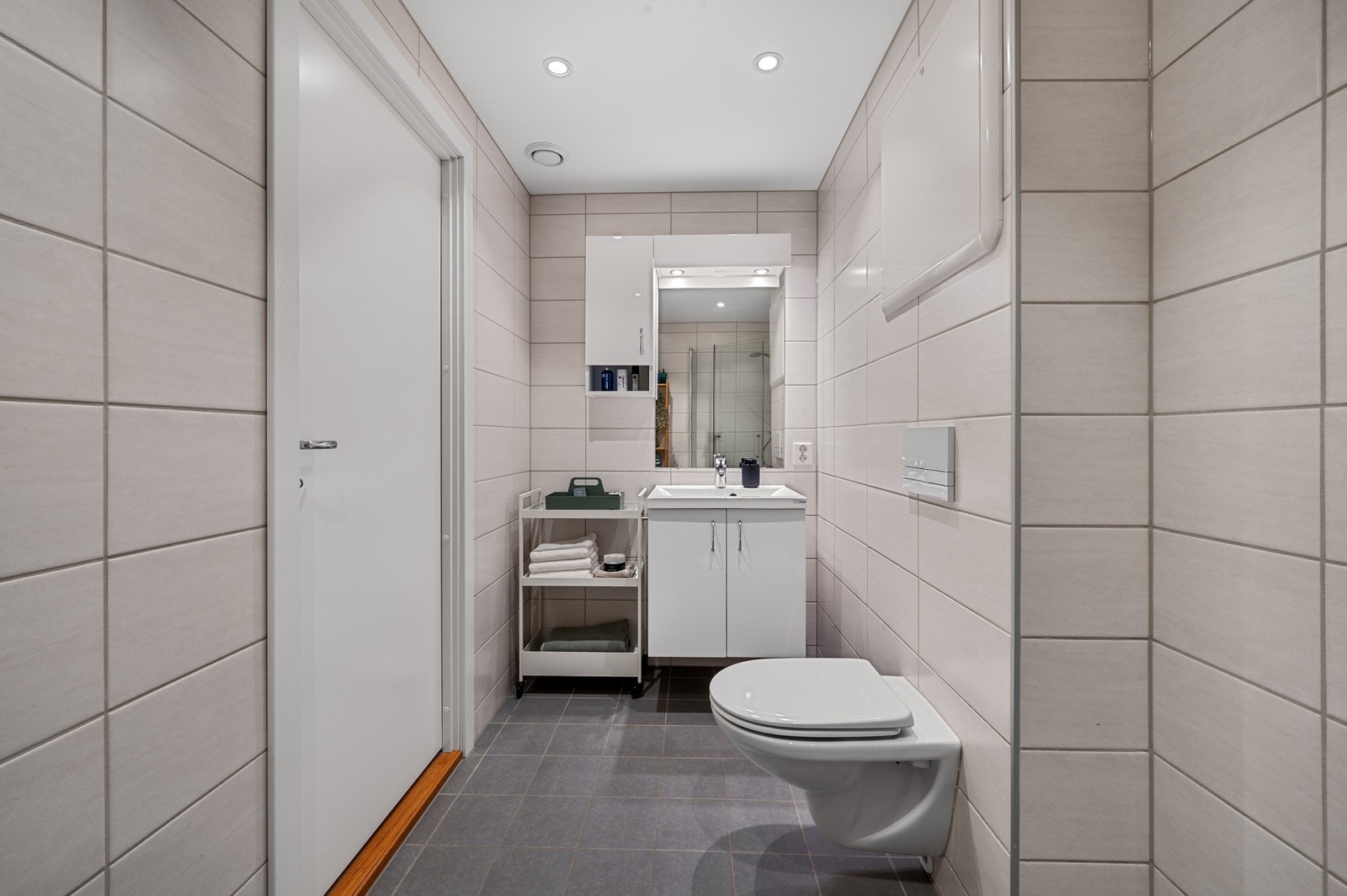 Helfliset baderom med varmekabler i gulv og spotter i tak. Galleribilde