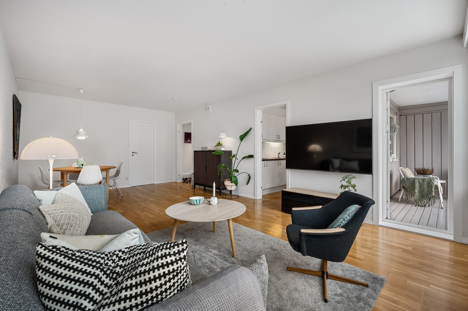 Romslig stue på 27,9kvm med 3-stavs parkettgulv og lyse overflater Galleribilde