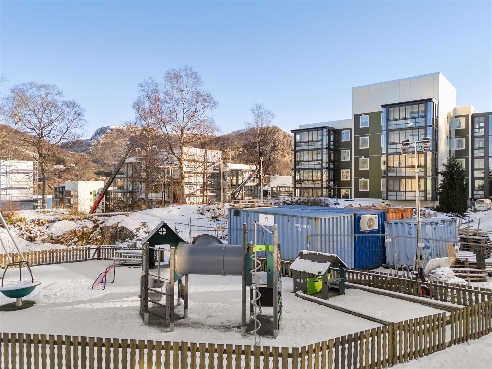 Blokken har en fin beliggenhet i laget, med enkel adkomst og lekeplass i front (containerene vil fjernes ved ferdigstillelse av oppussing) Galleribilde
