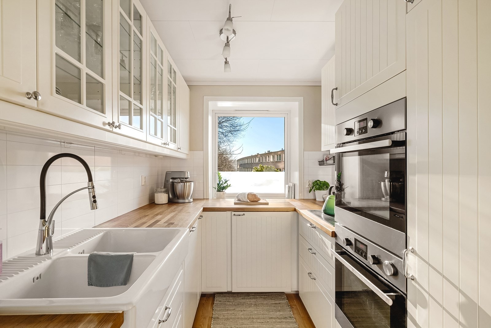 Det lyse Ikea-kjøkkenet fra 2014 har godt med skaper og gode arbeidsbenker. Fliser over benkeplate gjør renholdet enkelt og opplegg for oppvaskmaskin tar hånd om kjørlene. Dagslyset fra sør gir fint lys. Galleribilde