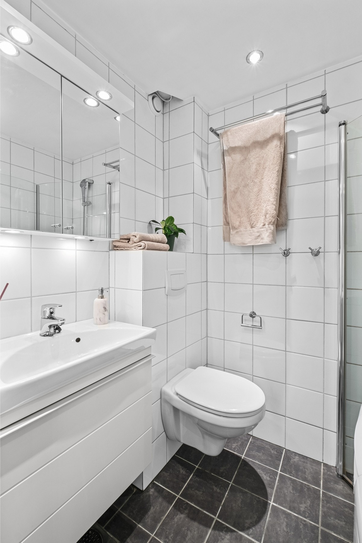 Leilighetens baderom betegnes som pent og moderne Galleribilde