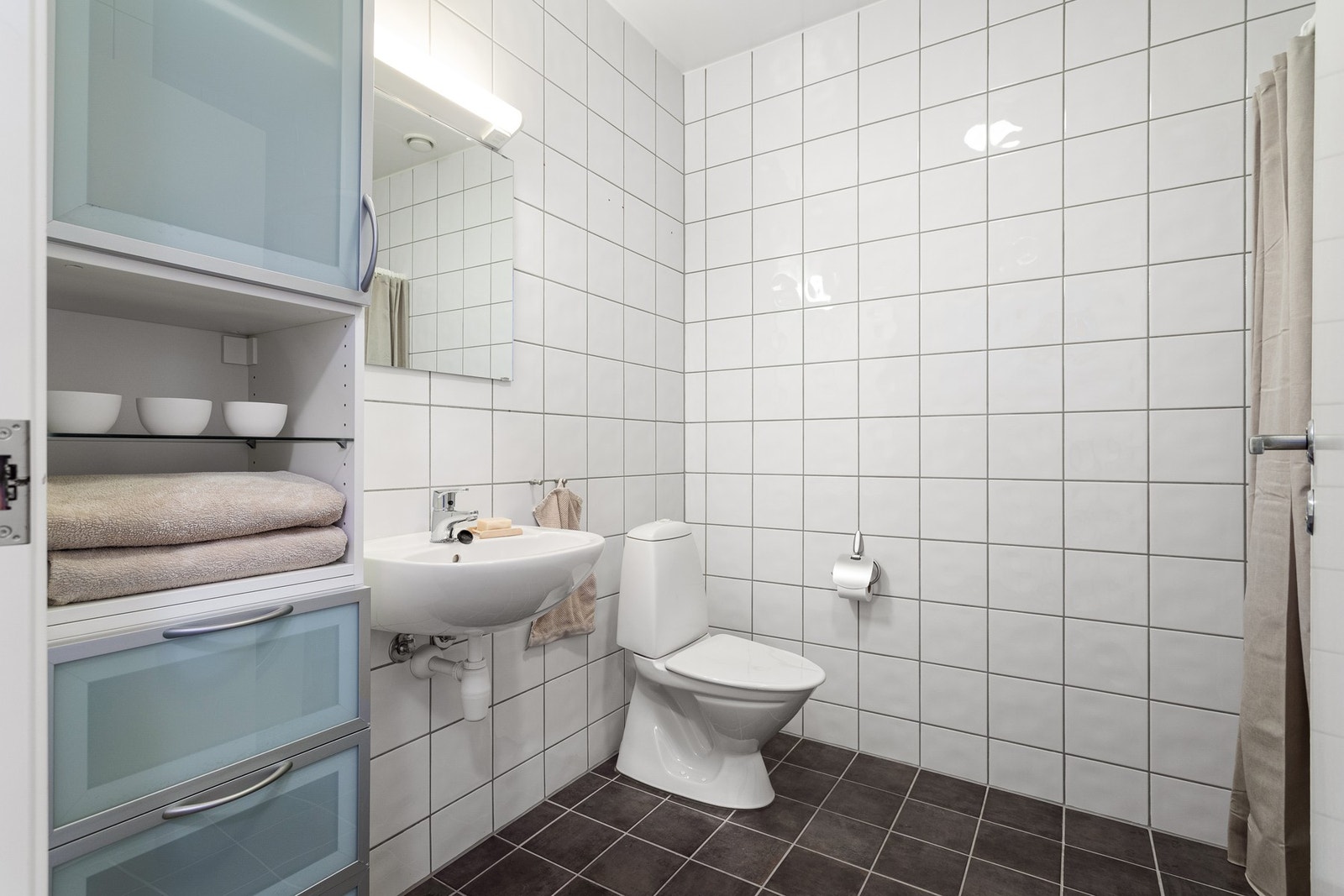 Lekkert og romslig flislagt bad på hele 5 kvadratmeter. Badet gir deg rikelig med plass til daglige rutiner og oppbevaring. Galleribilde