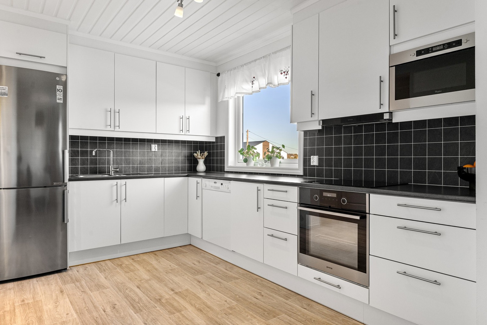 Kjøkkenet har moderne innredning med flate fronter og integrerte hvitevarer. Galleribilde