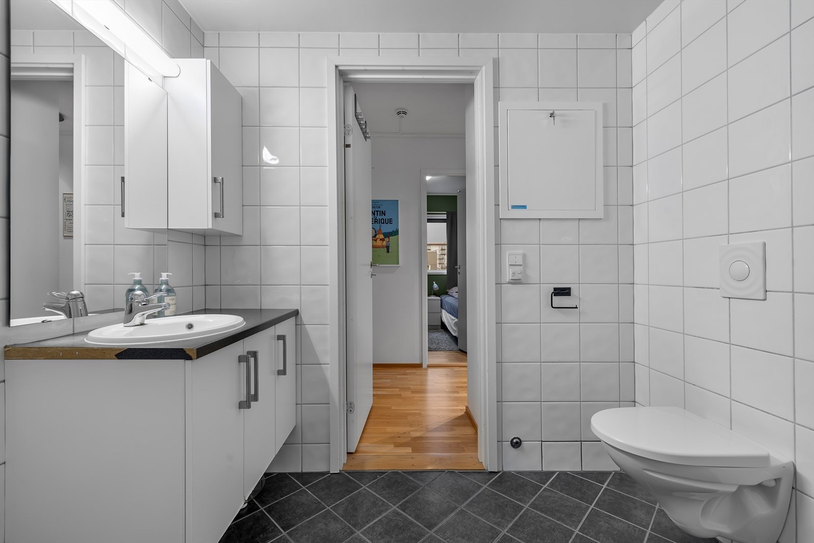 Badet er flislagt på vegg og gulv. Gulvvarme. Vegghengt WC. Galleribilde