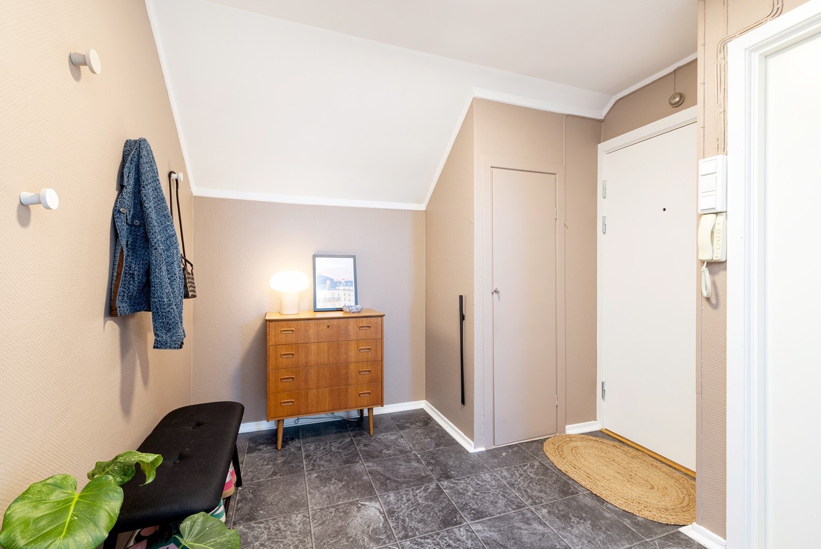 I leiligheten er det en romslig gang/entré med dør-calling og god plass til oppbevaring av ytterklær og sko. Fra gangen er det inngang til kjøkkenet, stuen, baderom samt et praktisk kott til oppbevaring. Galleribilde