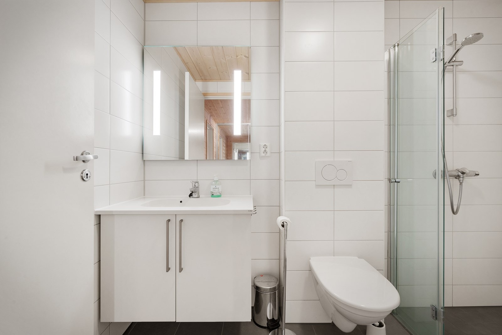 Praktisk baderomsinnredning med oppbevaringsplass og belyst speil Galleribilde