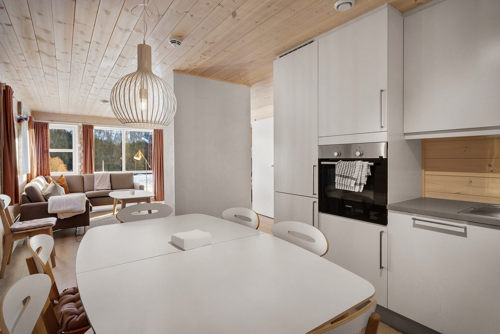 Kjøkkenet har hvite glatte fronter og laminert benkeplate med kjøkkenvask Galleribilde