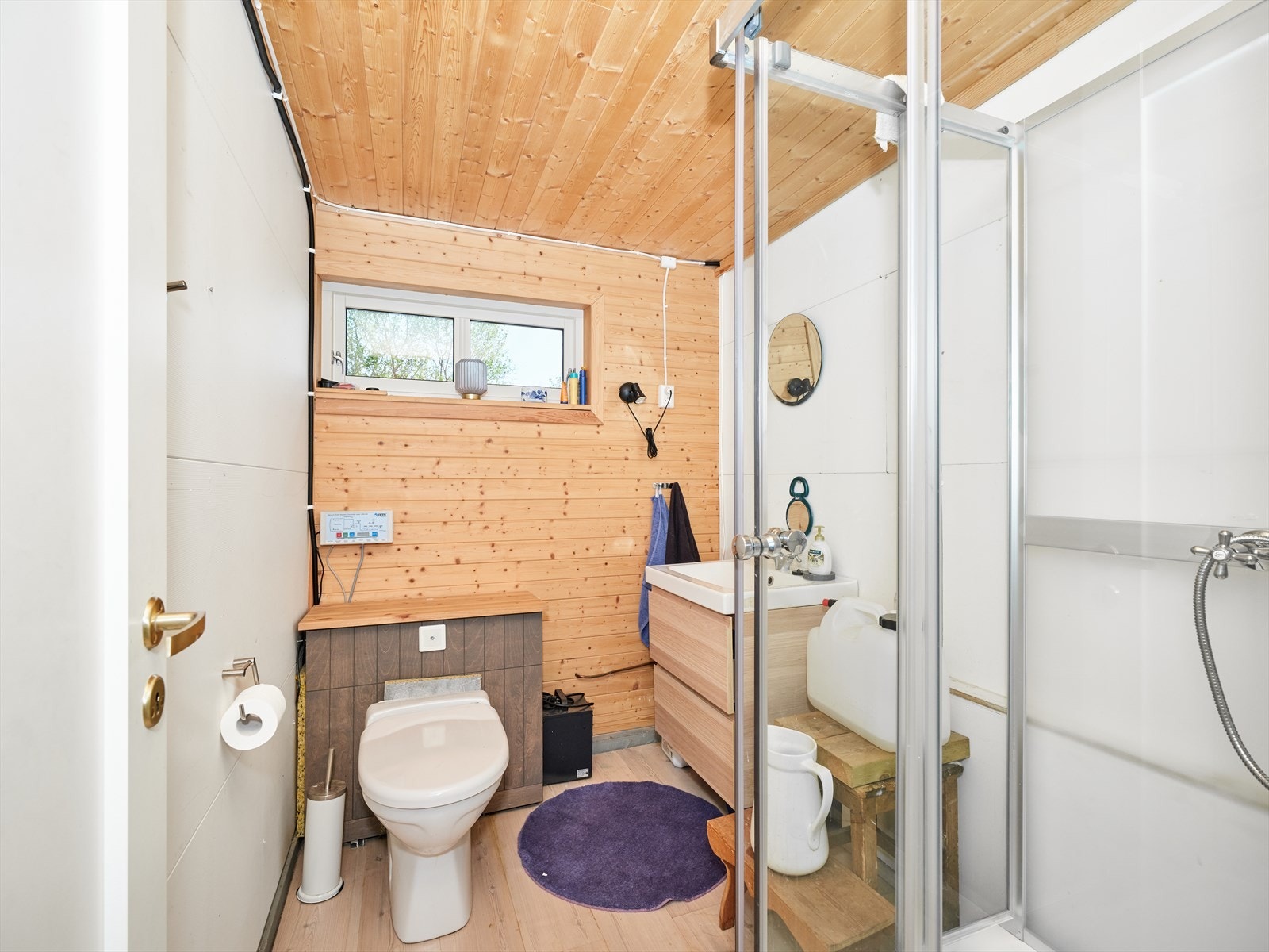 Hygienerom innredet med dusjkabinett, servant på innredning og vakumtoalett. Galleribilde