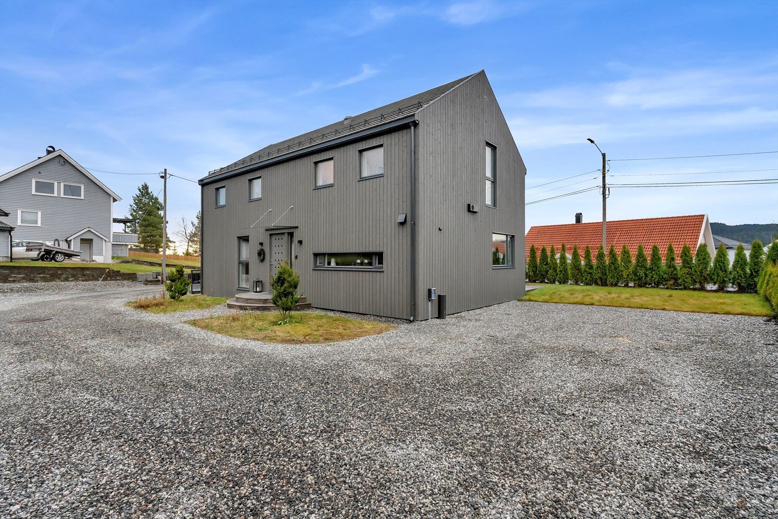 På høyresiden av boligen er det biloppstillingsplasser til eiendommen. Galleribilde