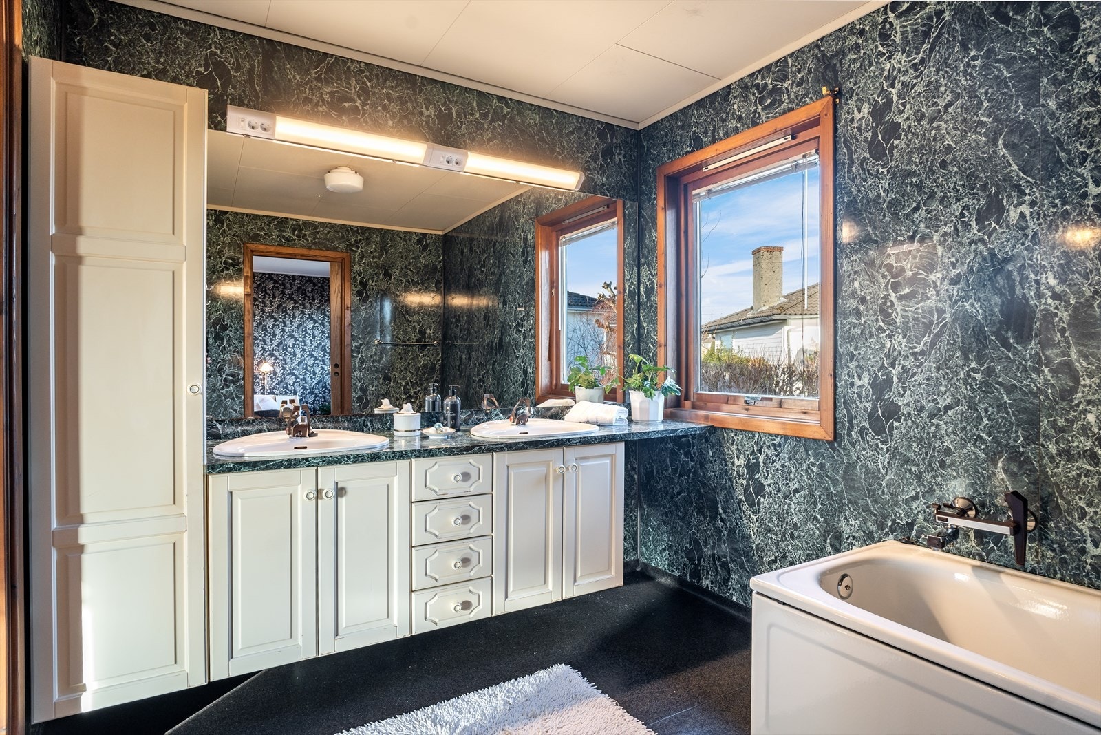 Stort bad som inneholder gulvstående toalett, bidè, badekar, stor innredning m/servant og sideskap. Galleribilde