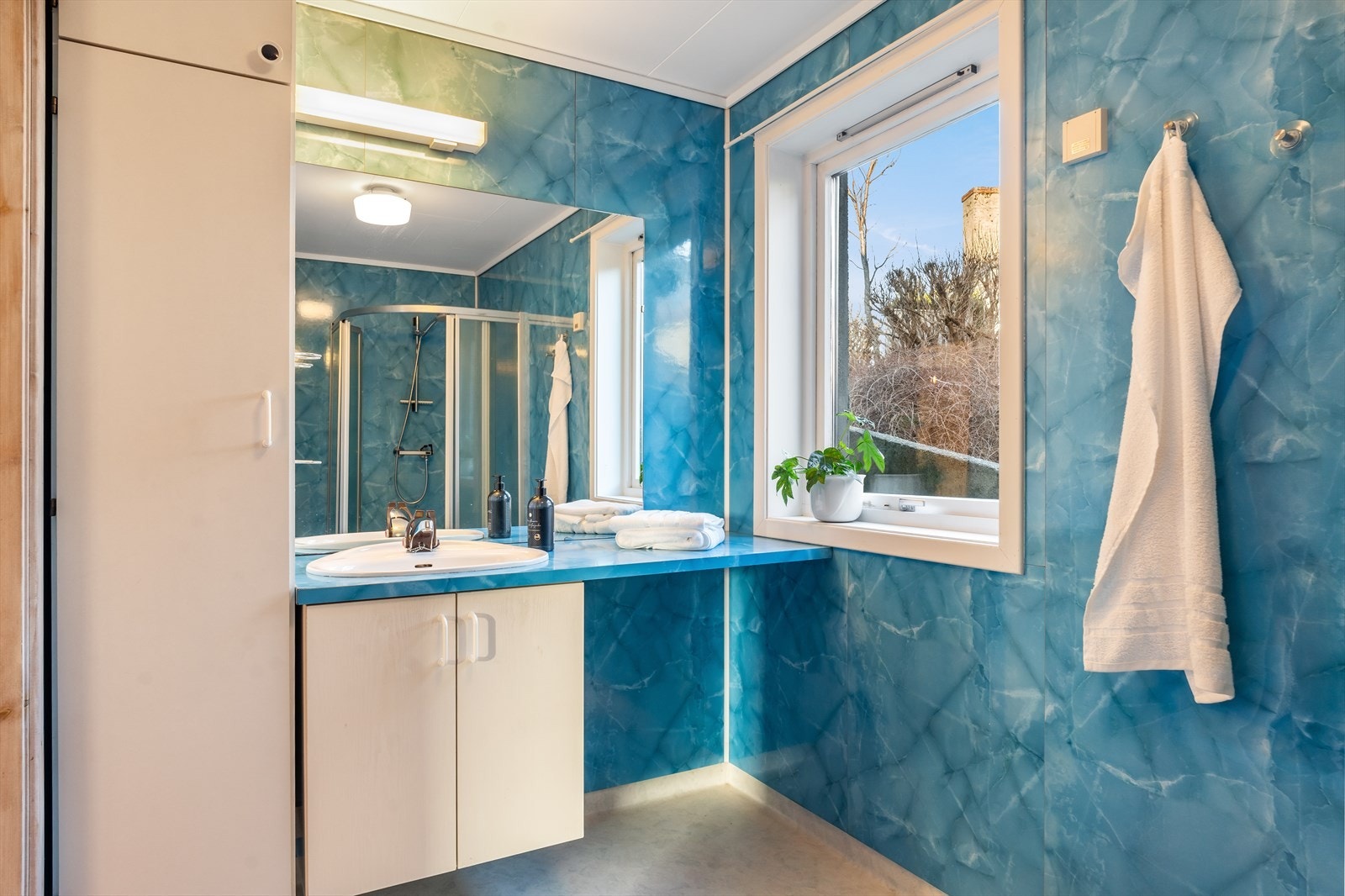 Sjarmerende bad med belegg på gulv og baderomsplater på vegg. Galleribilde