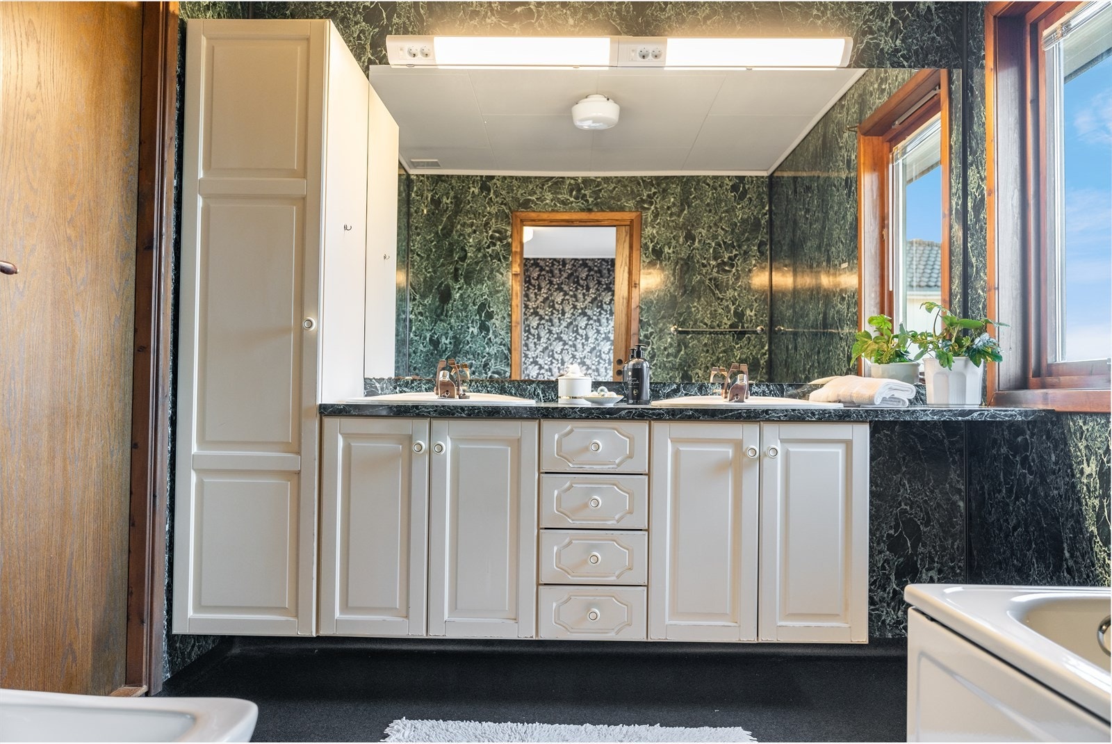 Stor innredning med rikelig plass til alle toalettsakene, håndklær m.m. Galleribilde