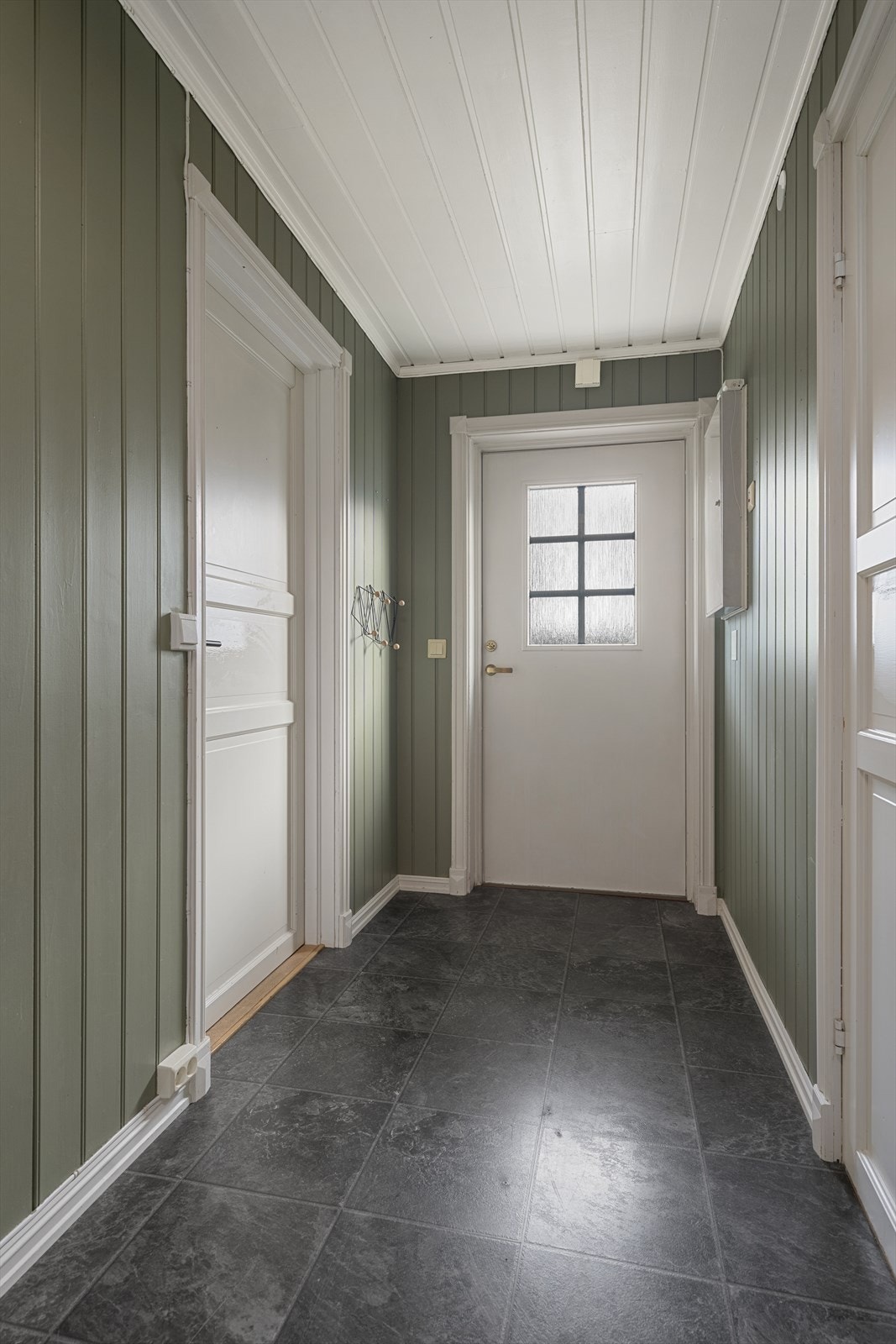 Fra en hyggelig og trappefri adkomst og delvis overbygd inngangsparti kommer du inn i boligens entré. Her er det plass til knaggrekke og skohylle Galleribilde