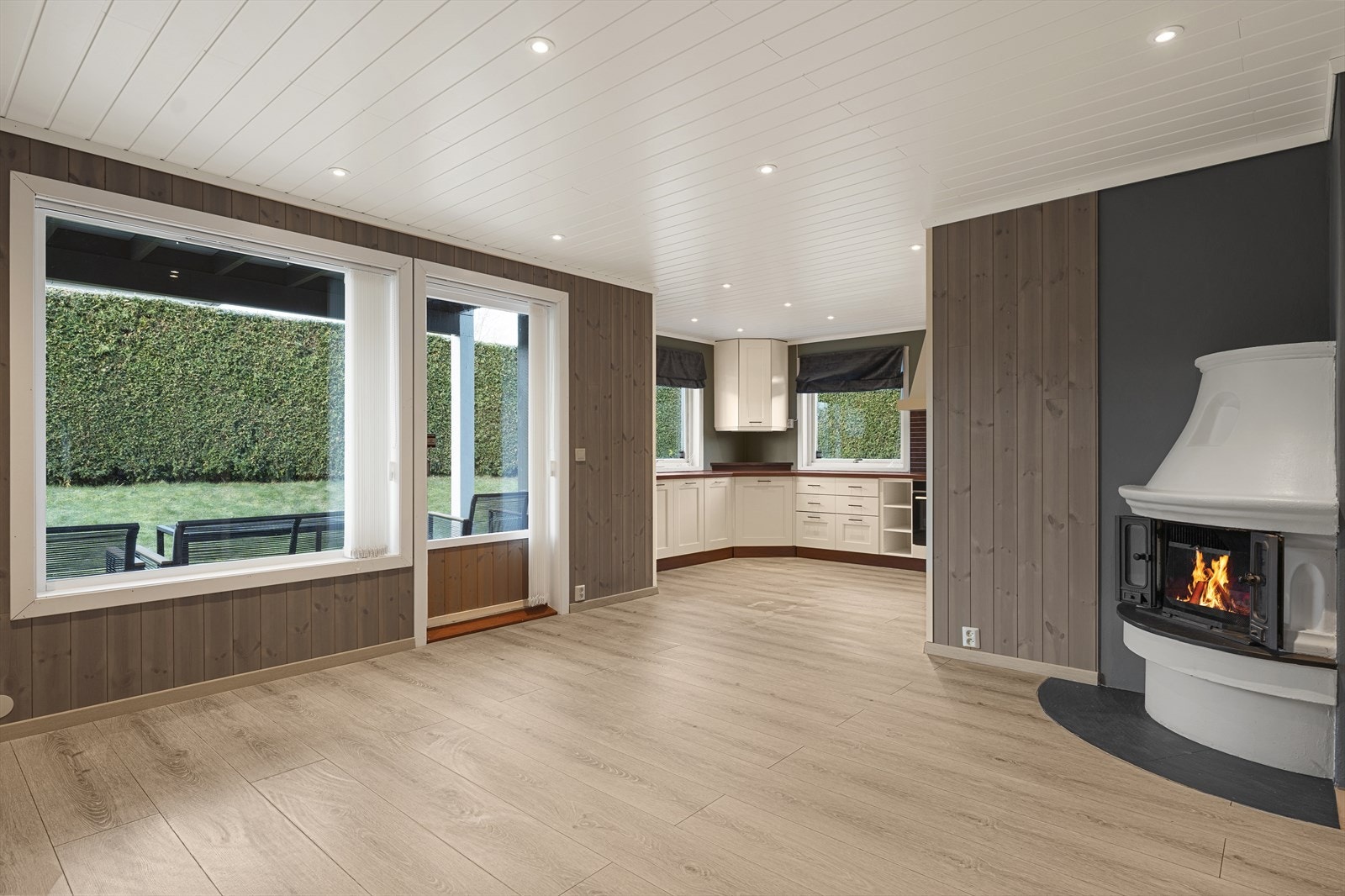 Stuen har nye overflater i 2021 med laminat på gulv, lysbeiset trepanel på vegger og MDF-panel med downlights i himling Galleribilde