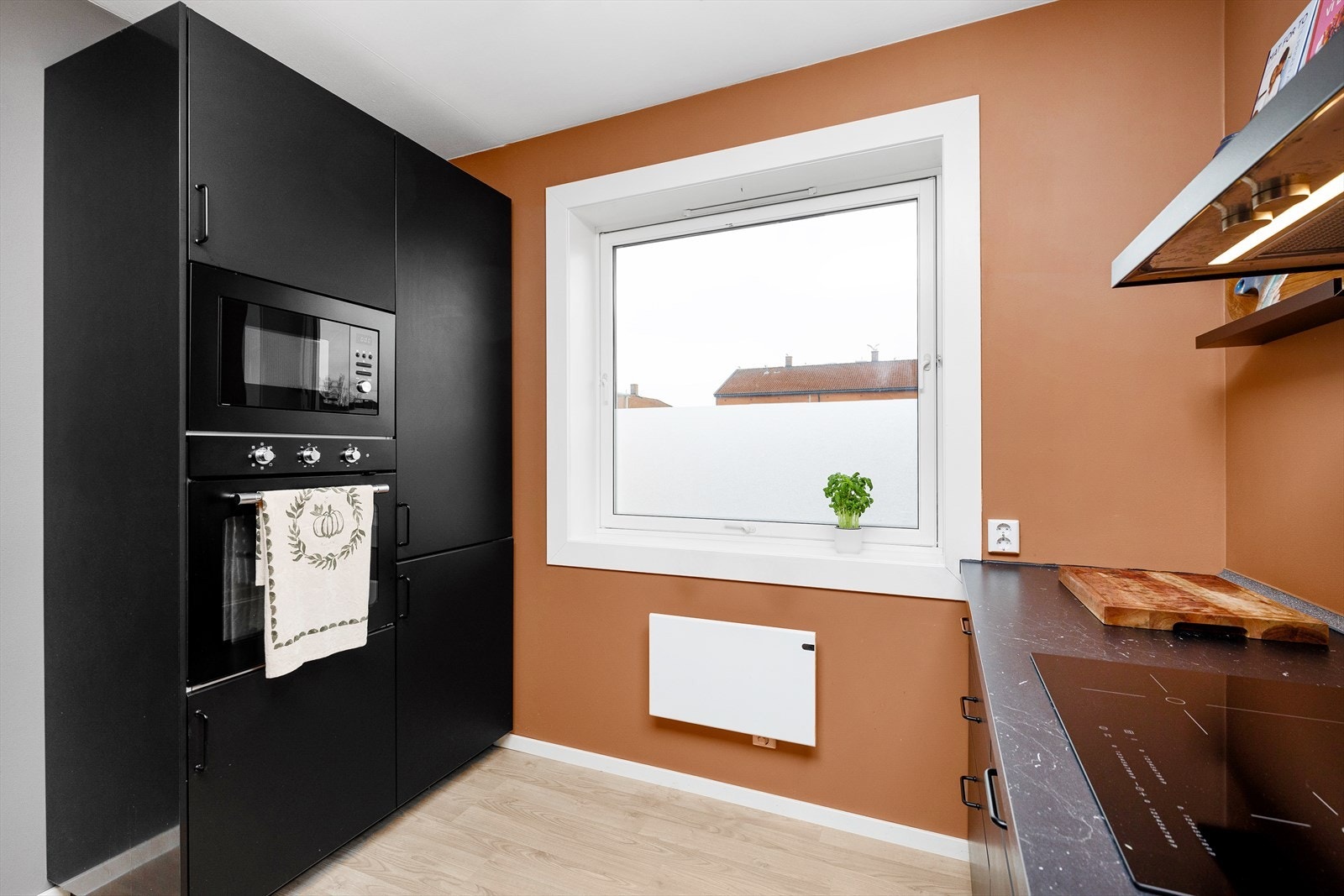 Moderne kjøkken med stilren design, integrerte hvitevarer og hyggelig utsyn Galleribilde