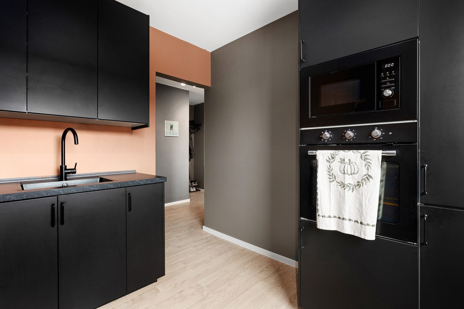 Moderne kjøkken med stilrene, mørke fronter og integrerte hvitevarer Galleribilde