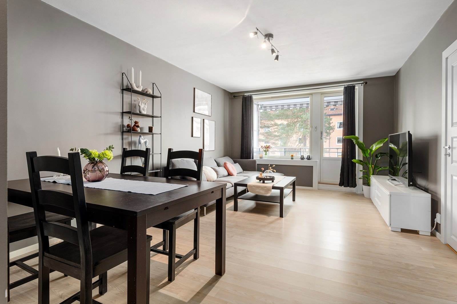 Lys og innbydende stue med utsyn til skjermet grøntområde Galleribilde