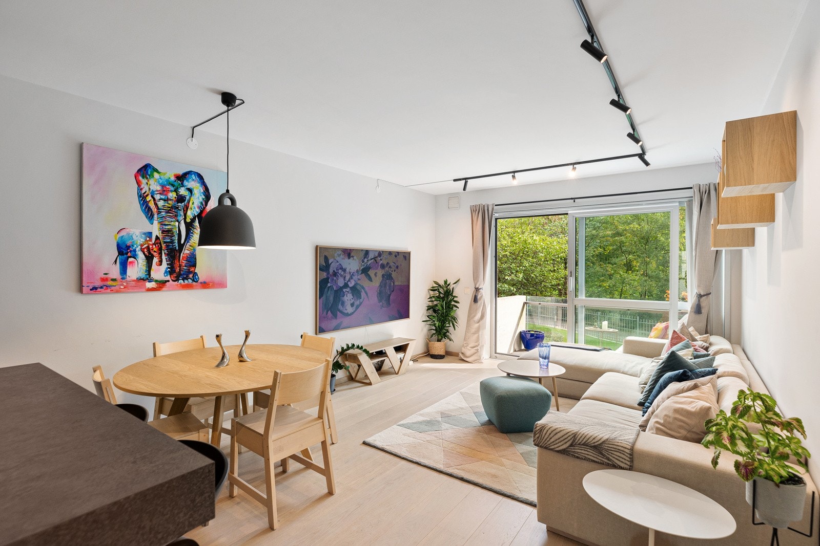 Den luftige stuen med frodig og idyllisk utsikt over Akerselva er leilighetens hjerte og sosiale samlingspunkt. Galleribilde