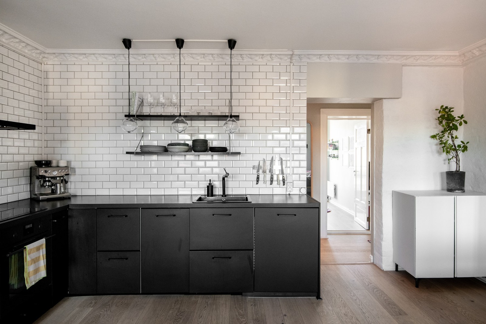 Her er det godt med skap- og benkeplass, samt åpne hyller på veggen som gir både oppbevaringsmuligheter og en dekorativ touch. Galleribilde