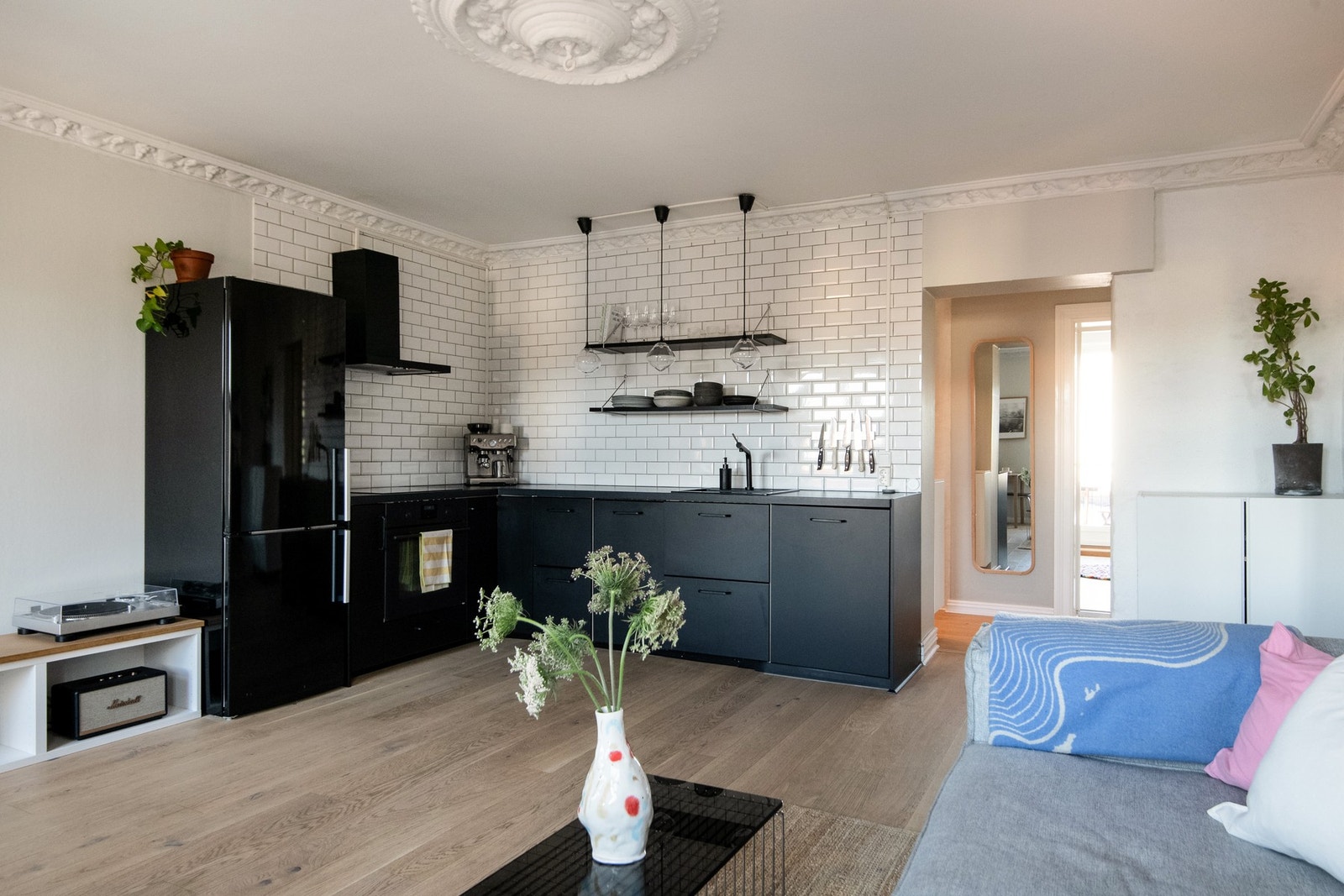 Med en praktisk plassering av kjøkkenet i hjørnet av stuen, er dette et rom perfekt for både hverdagsmatlaging og hyggelige sammenkomster. Galleribilde