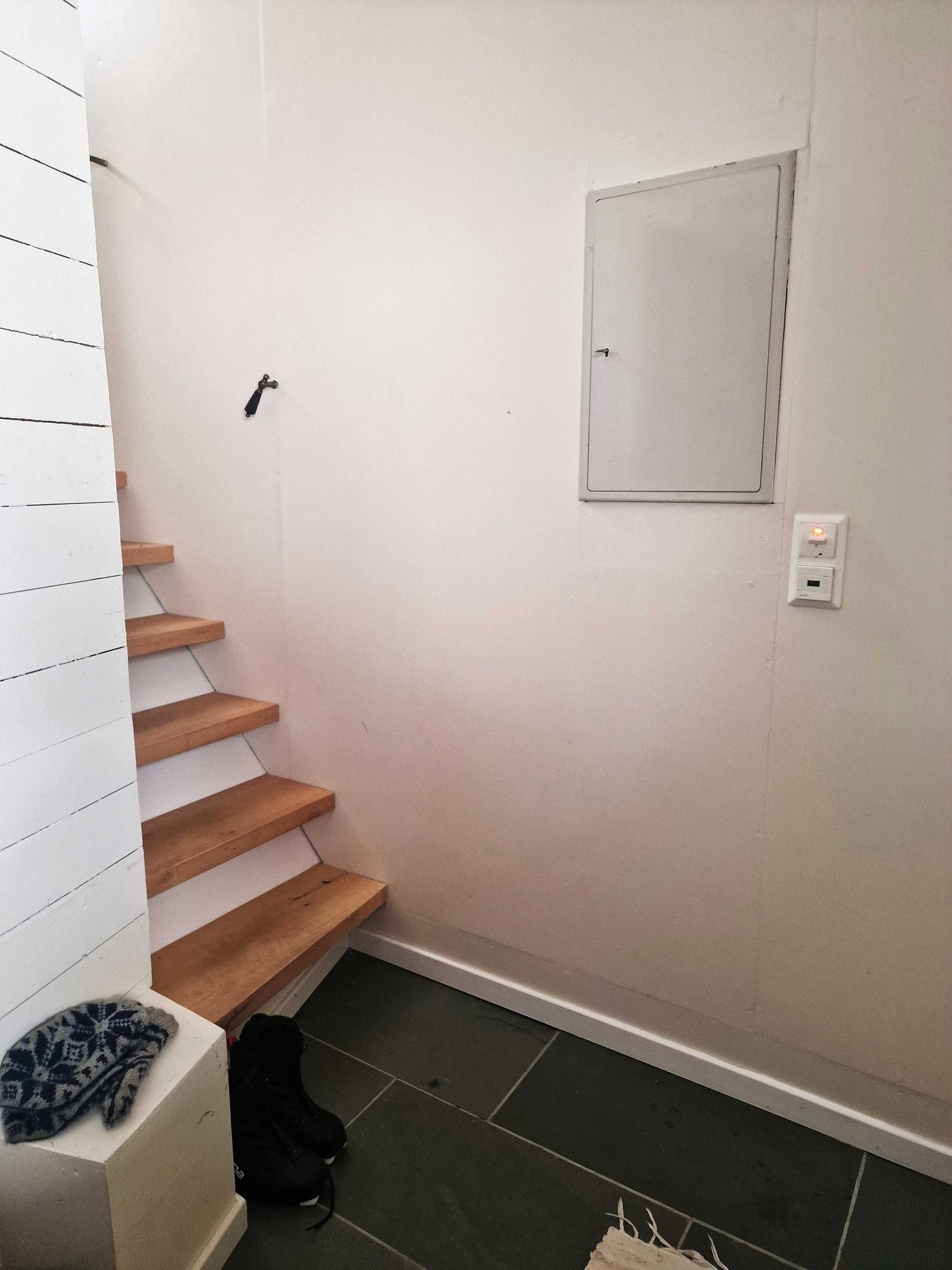 Inngang og trapp opp til øvre del. Fliser med varme i gulv. Her er det også garderobe med varmepumpe, luft til luft, som varmer begge bygningsdelene. Galleribilde