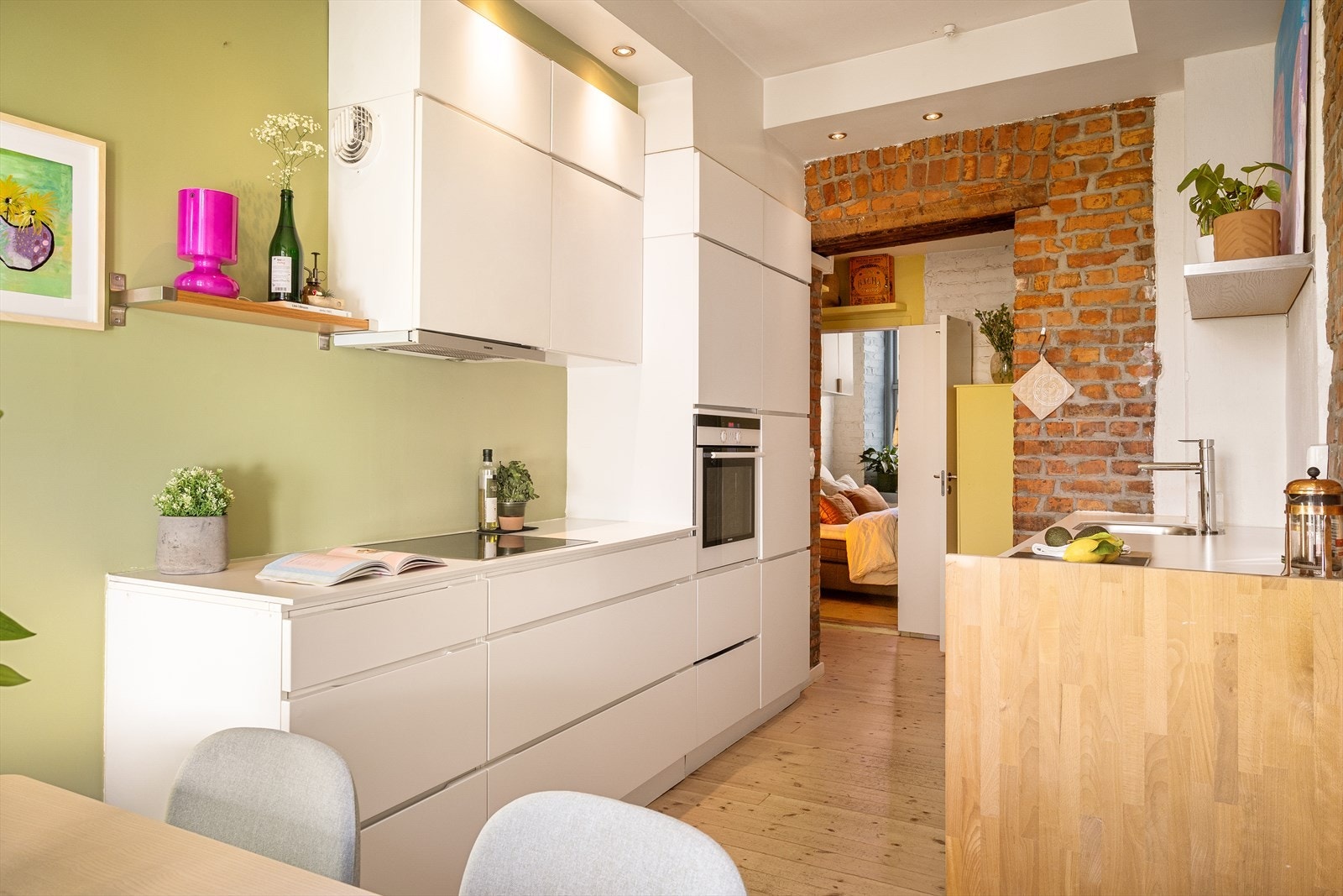 Kjøkkeninnredning med hvite glatte fronter, laminat benkeplate og underlimt oppvaskkum i stål. Induksjon platetopp, stekeovn, kombiskap og oppvaskmaskin medfølger salget. Galleribilde