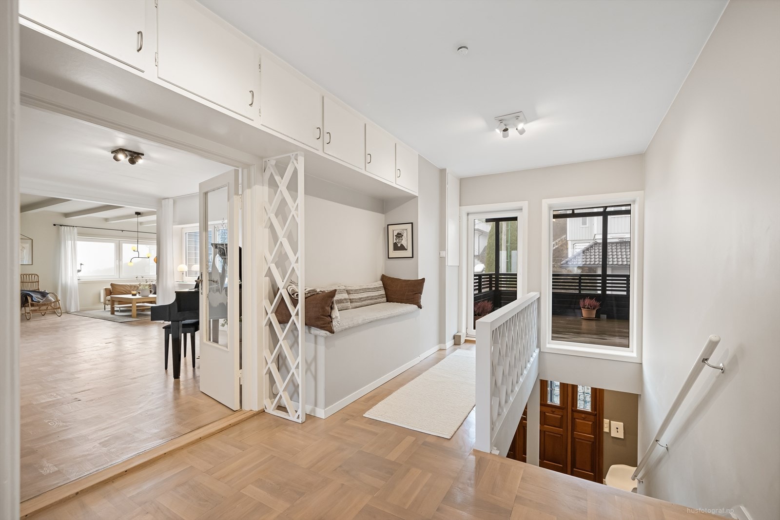 I gangen i 2.etasje er det bygget en sofakrok med oppbevaring, perfekt for avslapning med en bok eller en kopp kaffe. Med et gjennomført design fungerer den både som et praktisk møbel og en estetisk detalj som løfter helhetsinntrykket. Galleribilde